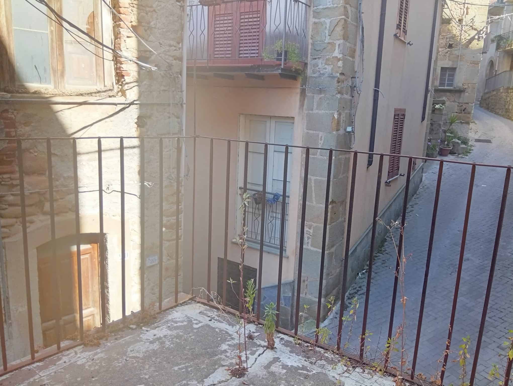 Balcone con ringhiera in ferro battuto e vista su strada in Via San Marco, Ficarra, Me.