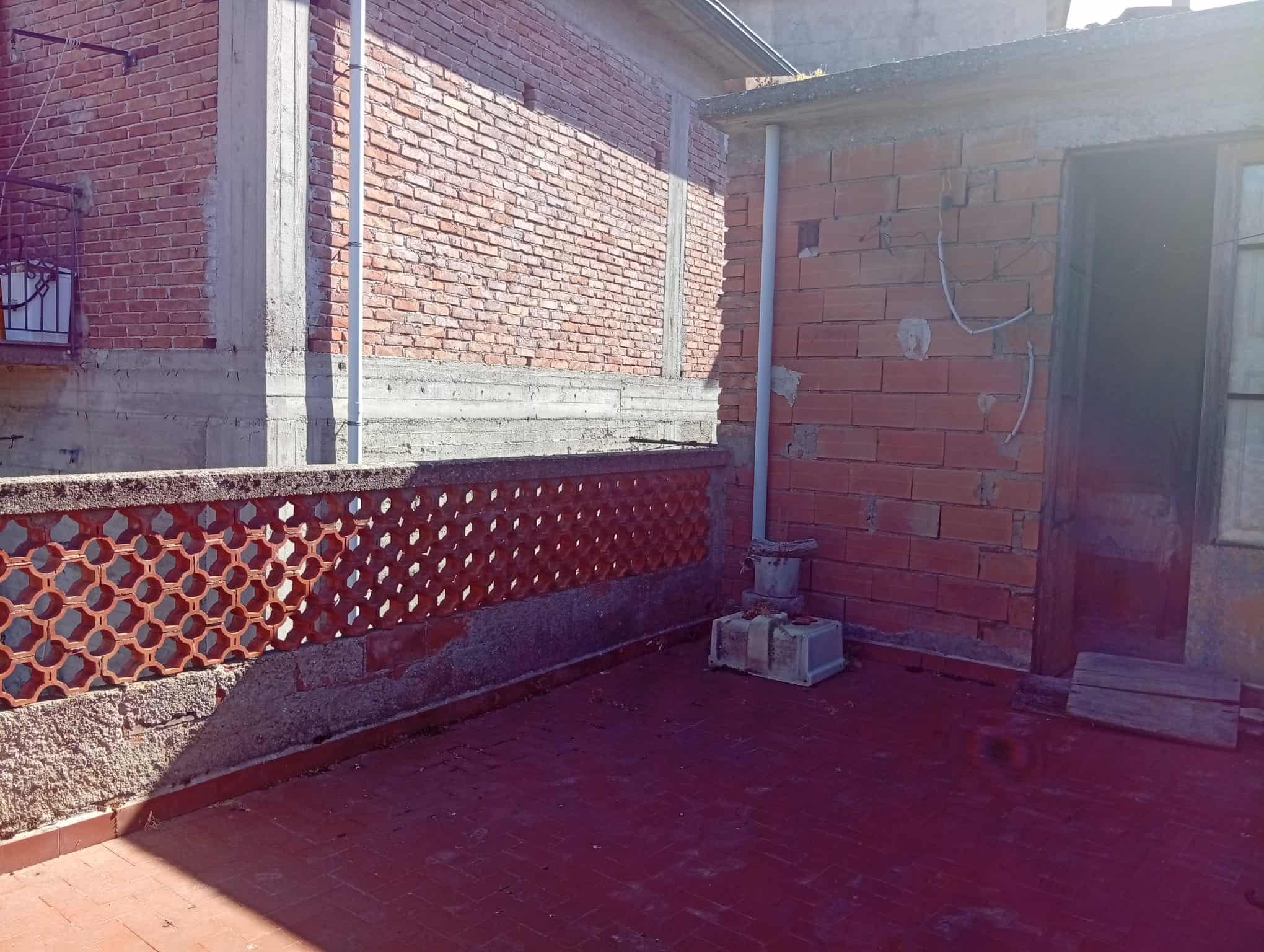 Terrazza di una casa semidipendente in vendita a Ficarra, con vista su muri in mattoni e pavimento in piastrelle rosse.