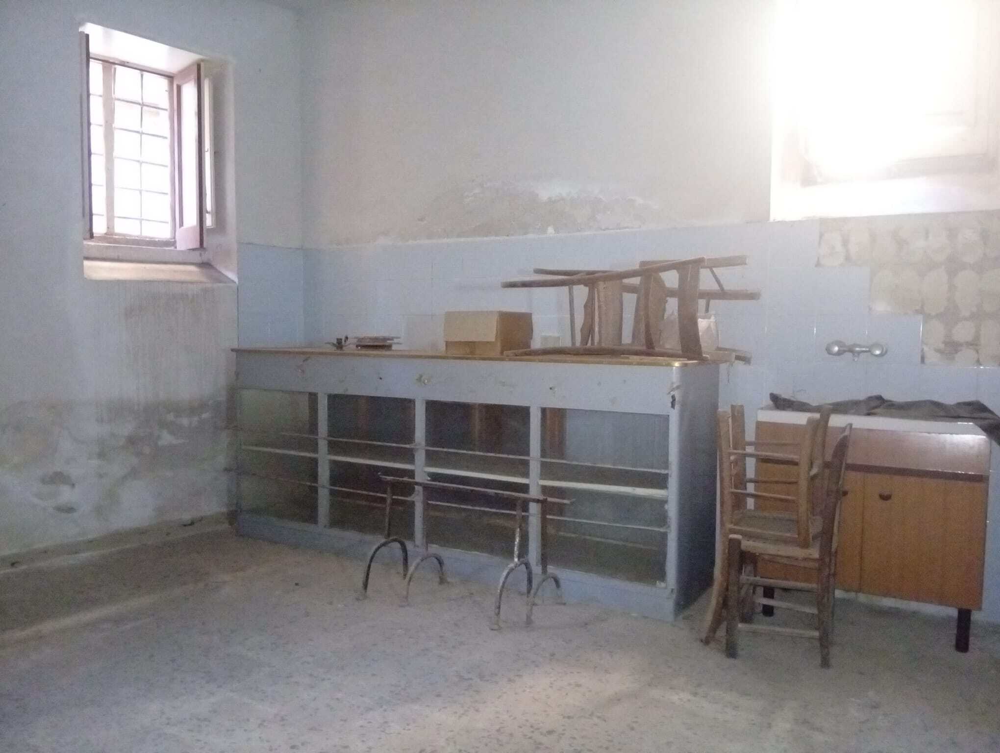 Interno di una casa semidipendente in vendita a Ficarra, con pareti in cattivo stato e mobili vecchi.