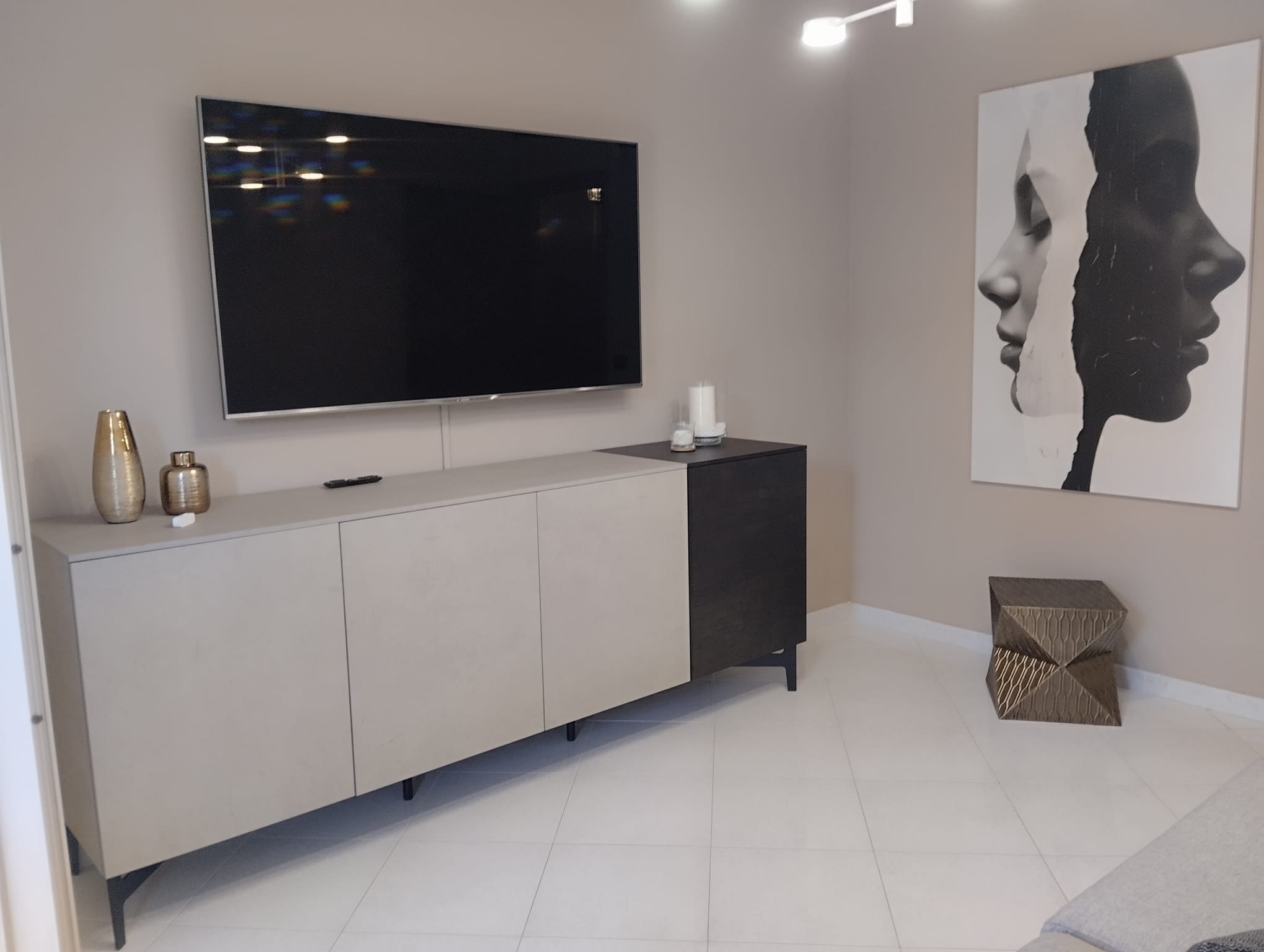 Interni moderni di un appartamento in vendita a Acquedolci, con TV, mobile e decorazioni eleganti.