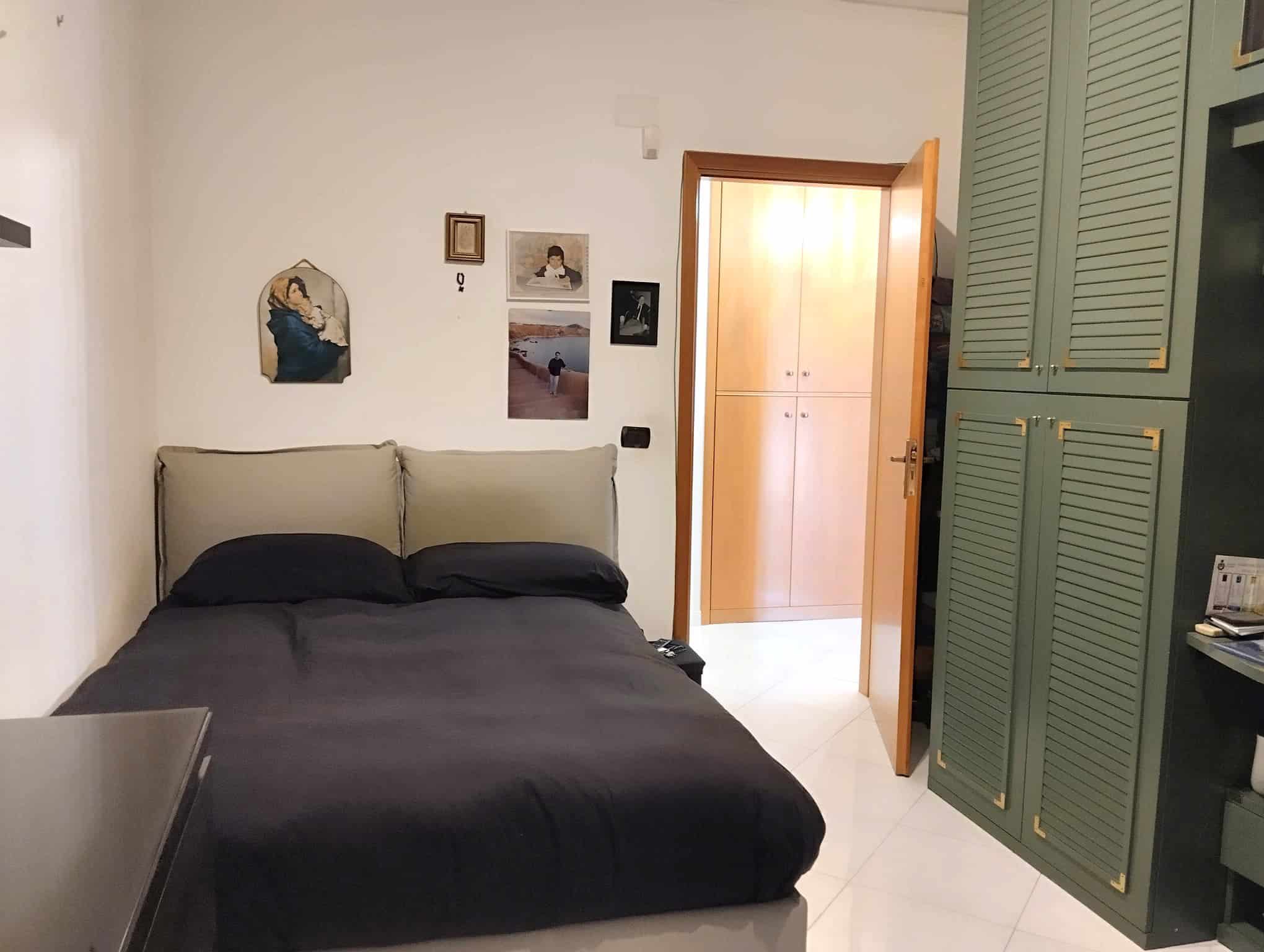 Camera che mostra una camera da letto con letto matrimoniale, pareti decorate e armadio verde, in un appartamento in vendita a Acquedolci, Me.
