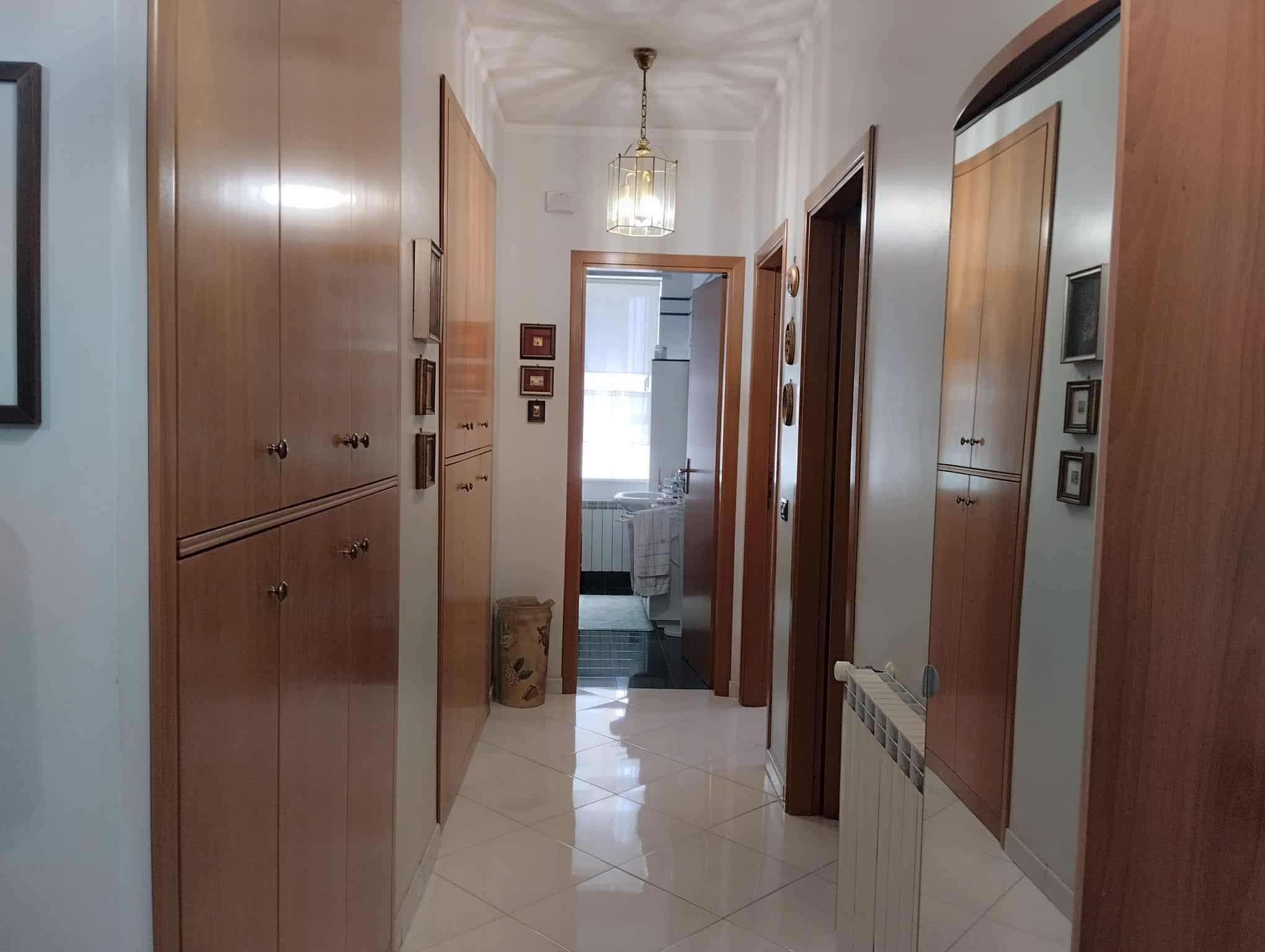 Ingresso di un appartamento in vendita in Via Generale di Giorgio, Acquedolci, con armadiature in legno e illuminazione centrale.