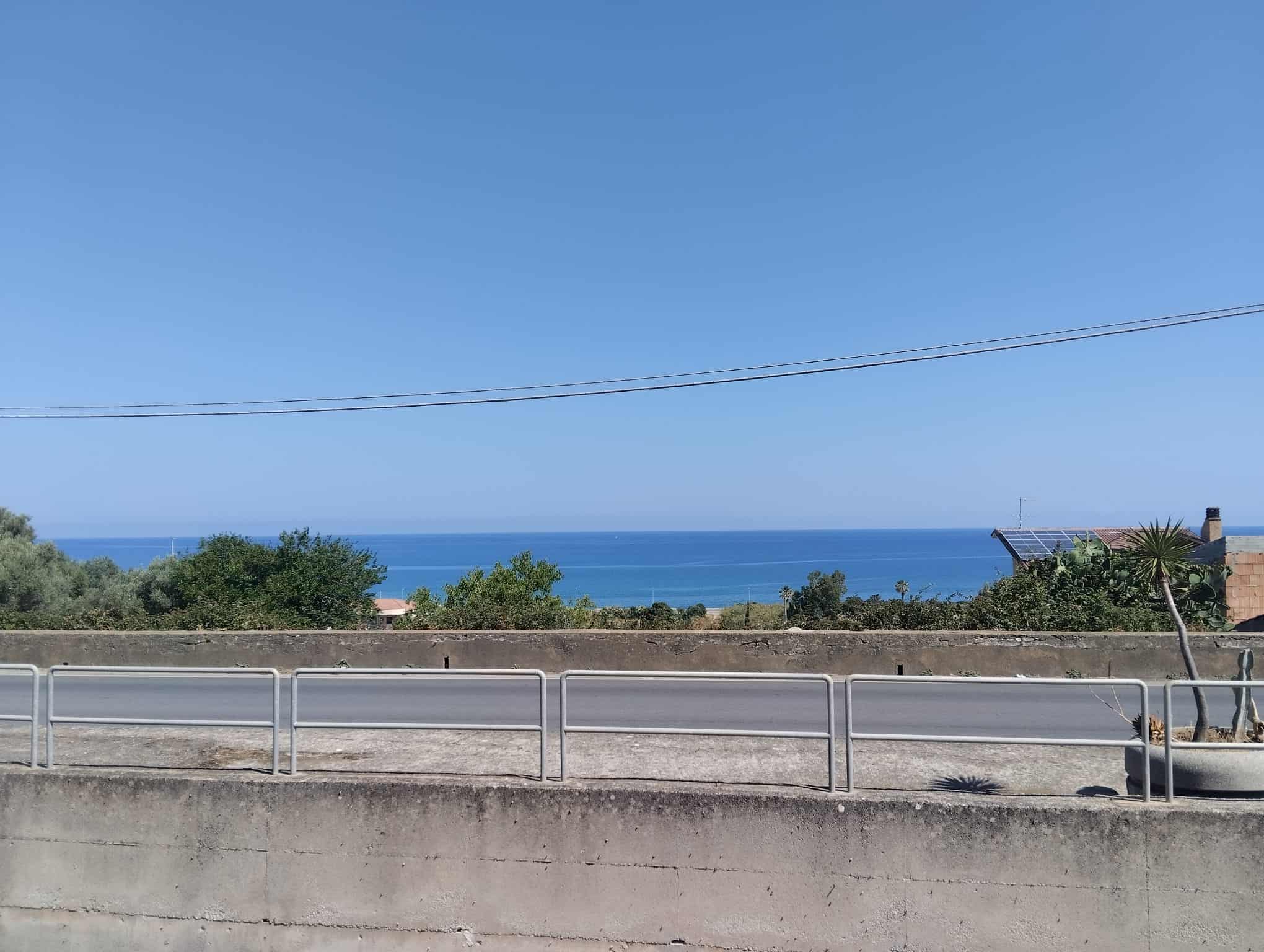 Vista panoramica sul mare e sulla costa di Acquedolci, Sicilia, con cielo sereno e mare calmo.