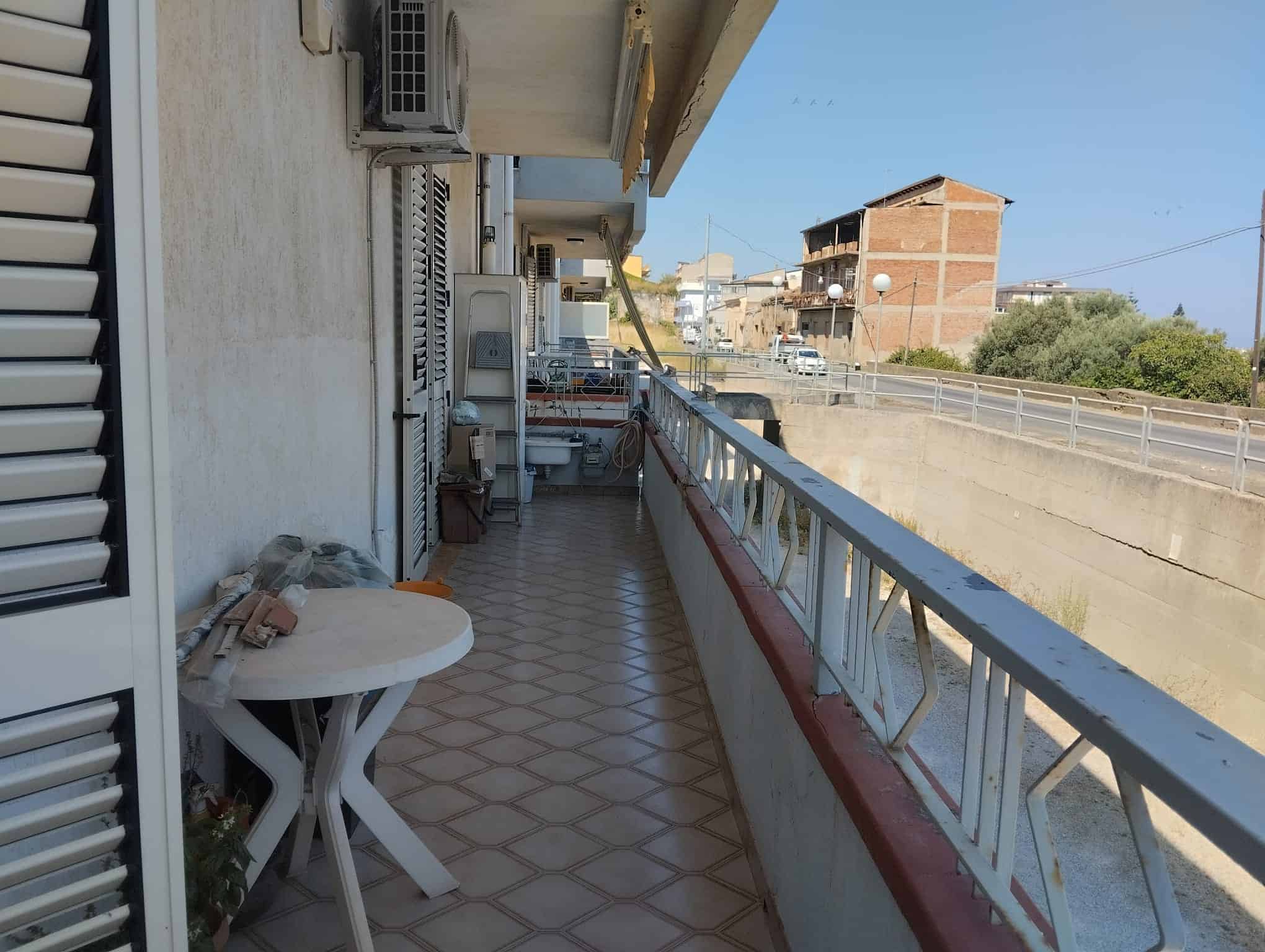Balcone di un appartamento in vendita a Acquedolci con vista sulla strada e edifici circostanti.
