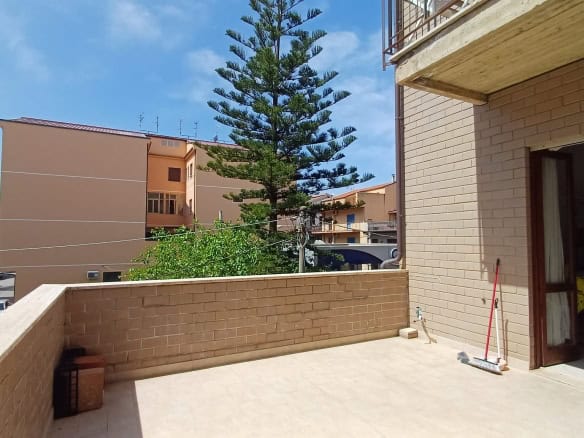 Balcone di un appartamento con vista su edifici e alberi, in zona residenziale a Rocca di Capri Leone.