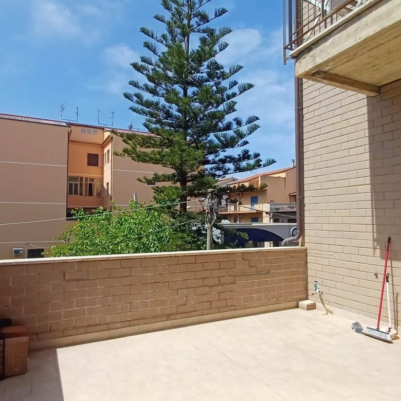 Balcone di un appartamento con vista su edifici e alberi, in zona residenziale a Rocca di Capri Leone.