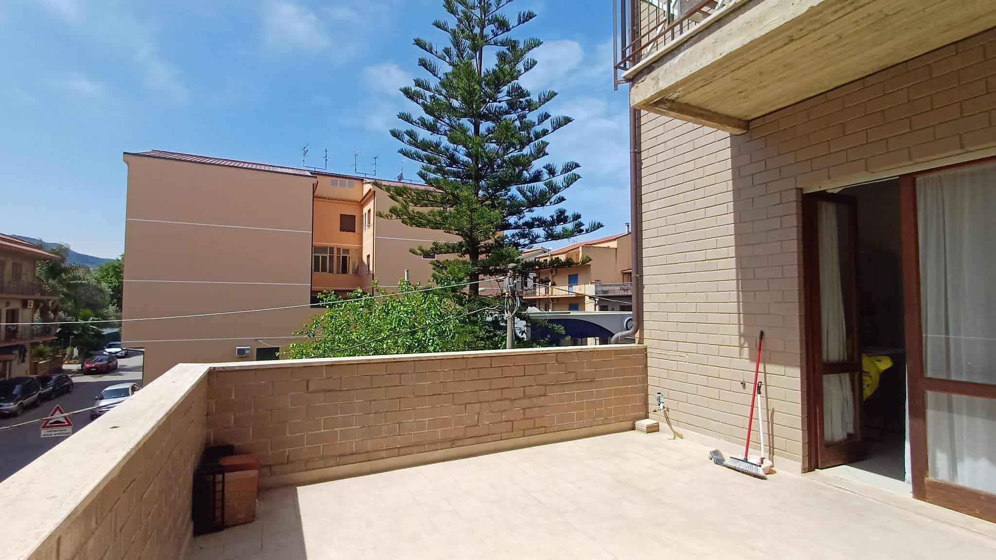 Balcone di un appartamento con vista su edifici e alberi, in zona residenziale a Rocca di Capri Leone.