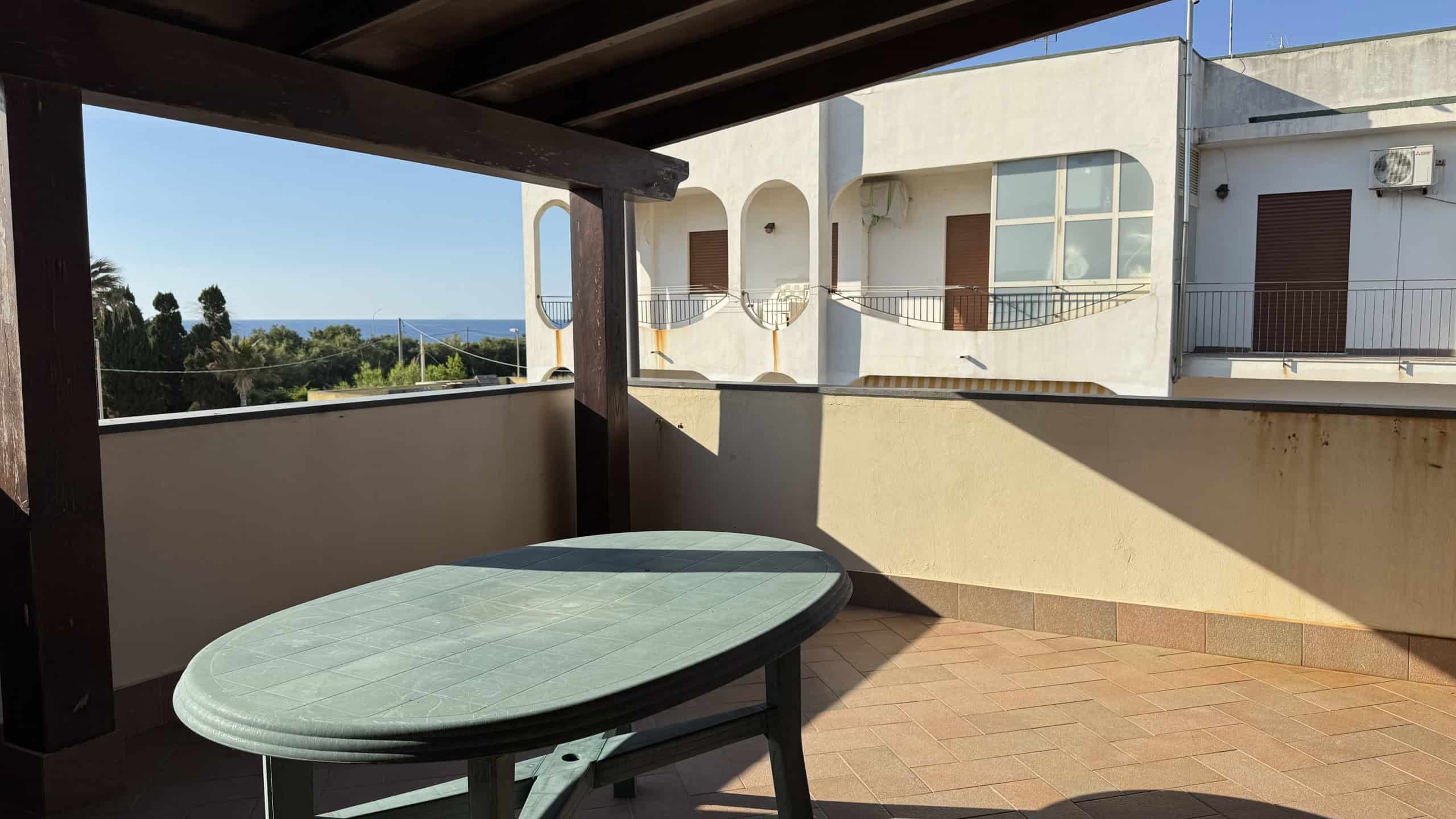 Spaziosa terrazza con vista panoramica sul mare, arredamento elegante e spazio esterno ideale per relax e convivialità. Perfetta per vivere momenti all'aperto in un contesto residenziale di qualità.