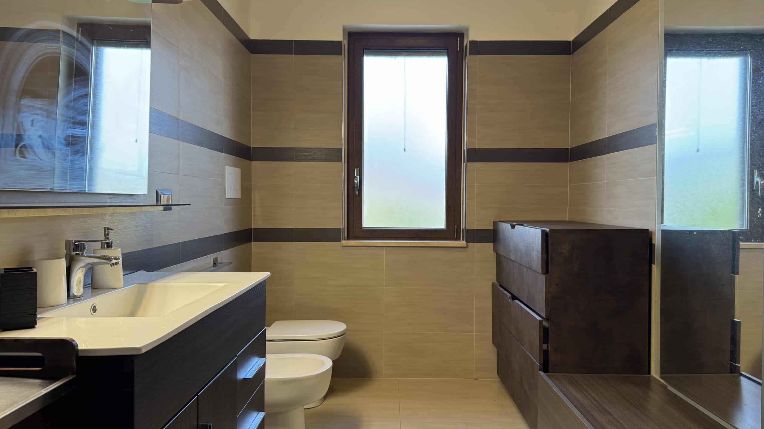 Bagno spazioso con lavabo, WC e finestra in villa unifamiliare in vendita a Corriolo, Me.