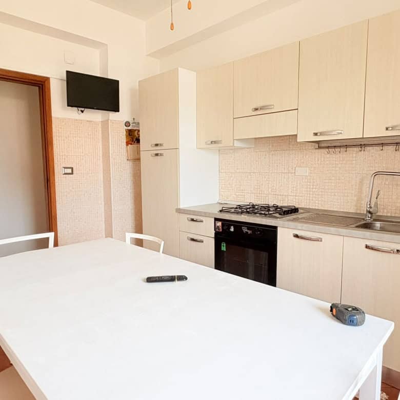 Cucina moderna in appartamento in affitto a Milazzo con mobili chiari e elettrodomestici.