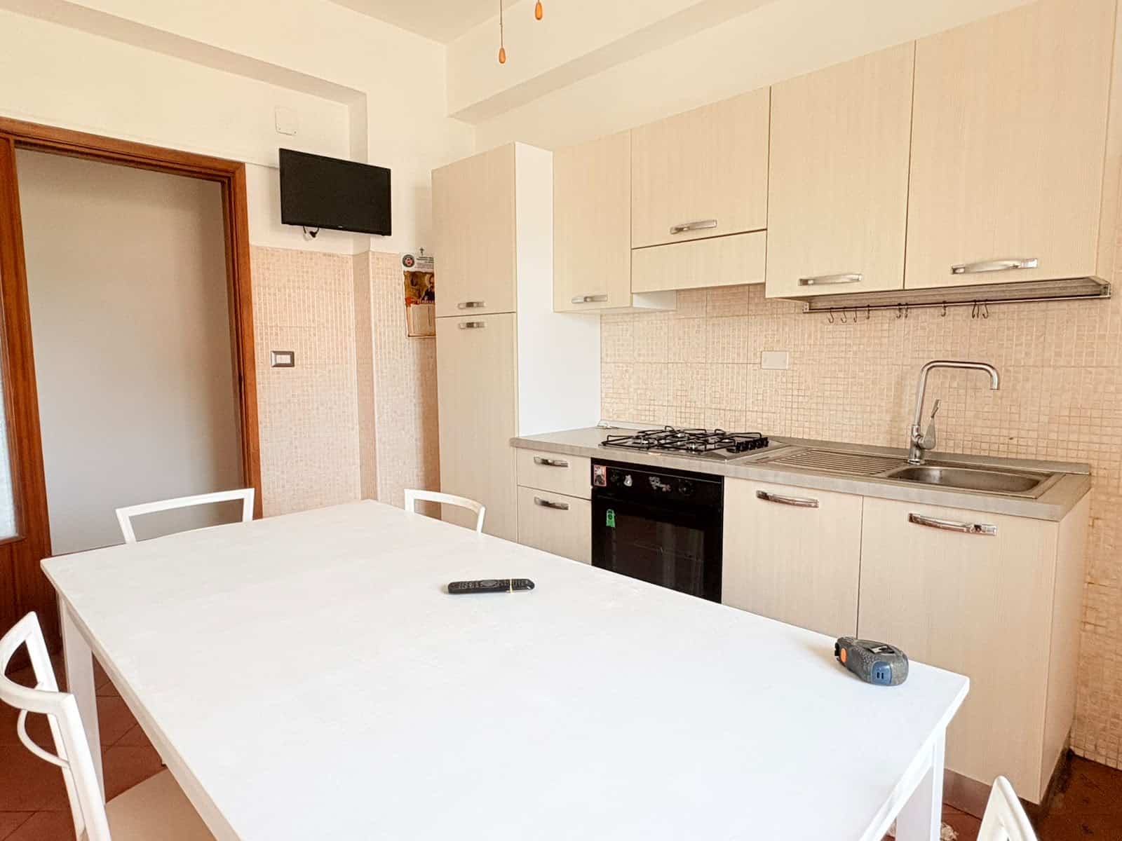 1 Cucina moderna in appartamento in affitto a Milazzo con mobili chiari e elettrodomestici.