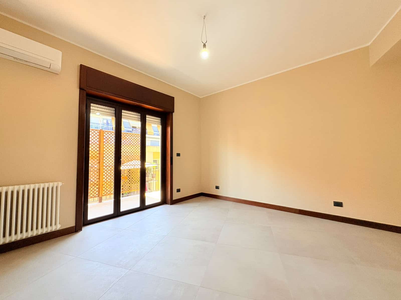Ampio soggiorno con porta finestra che dà su un balcone, aria condizionata e riscaldamento autonomo, ideale per appartamento in vendita a Milazzo.