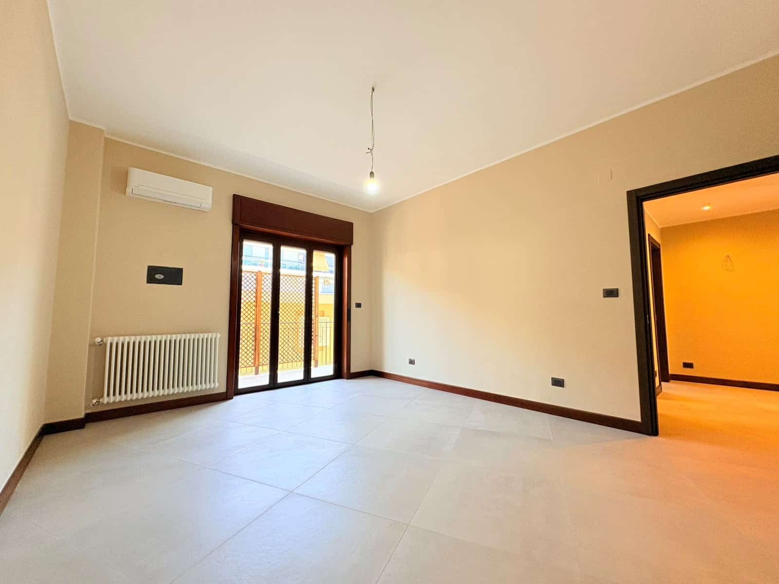 Ampio soggiorno luminoso con porta finestra e aria condizionata in appartamento in vendita a Milazzo.