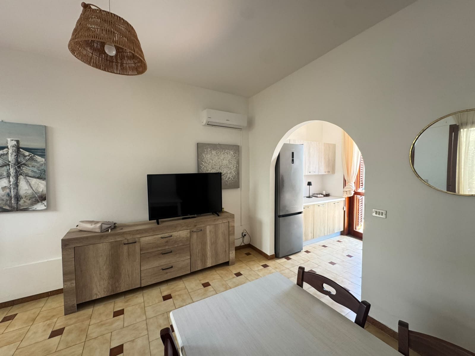 Interno di una casa in vendita a Milazzo con soggiorno e cucina a vista, arredi moderni e atmosfera accogliente.