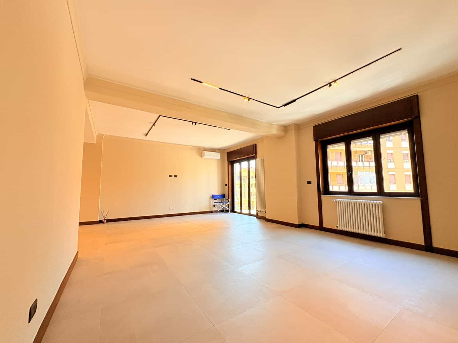Ampio soggiorno luminoso con grandi finestre e pavimento in ceramica, ideale per appartamento in vendita a Milazzo.
