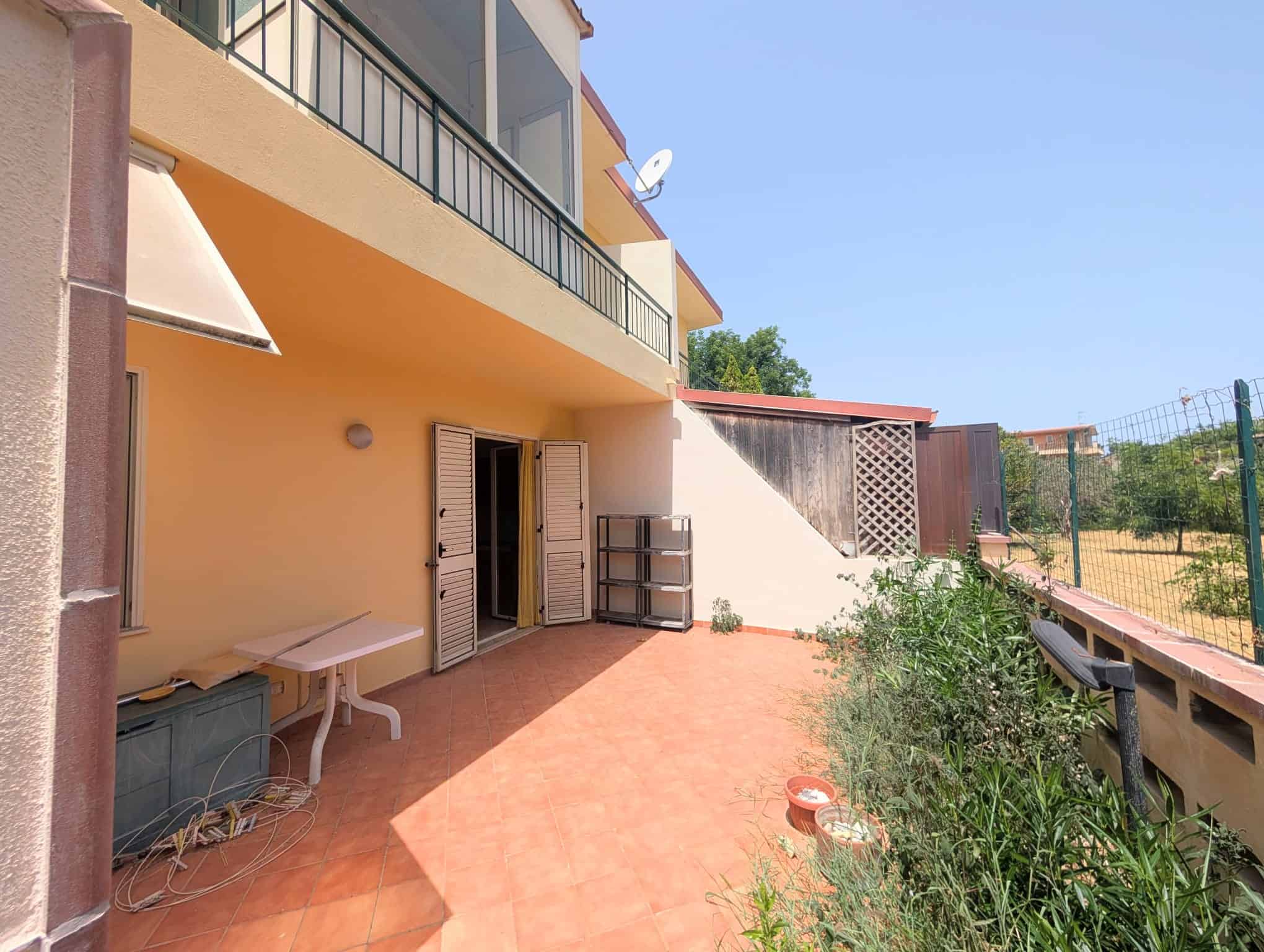 Terreno esterno di una villetta a schiera con patio e giardino, spazio esterno privato, ideale per relax e attività all'aperto.
