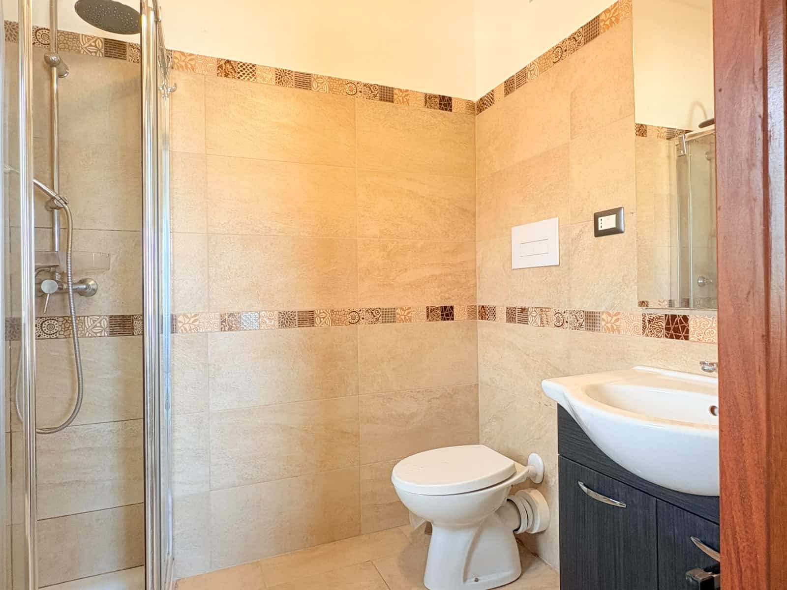 Bagno moderno con doccia, WC e lavabo in un appartamento in affitto a Milazzo.