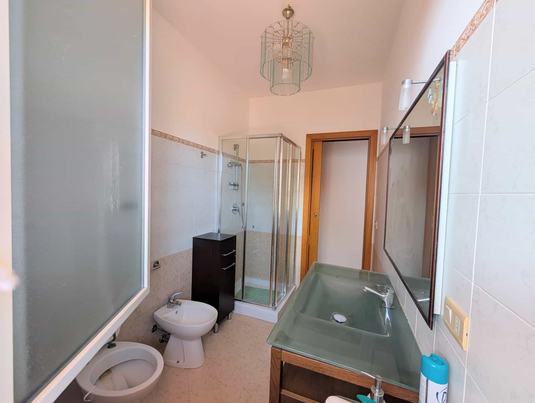 Bagno di una villetta a schiera con doccia, lavabo e bidet, arredato in stile semplice e funzionale.