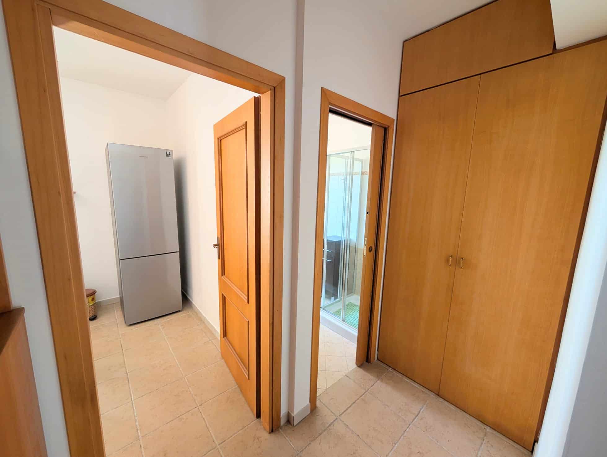 Vista dell'ingresso di una villetta a schiera con armadio a muro e porta verso il balcone, ambiente luminoso e funzionale.