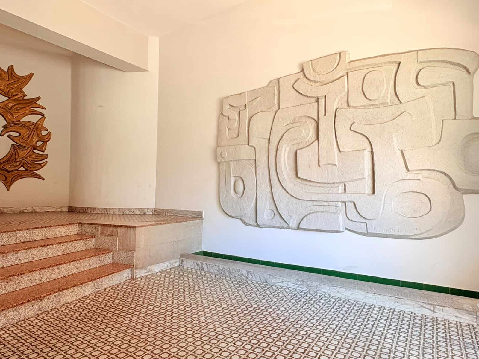 Ingresso di un appartamento in vendita a Milazzo con decorazioni artistiche sulla parete e pavimento in piastrelle.