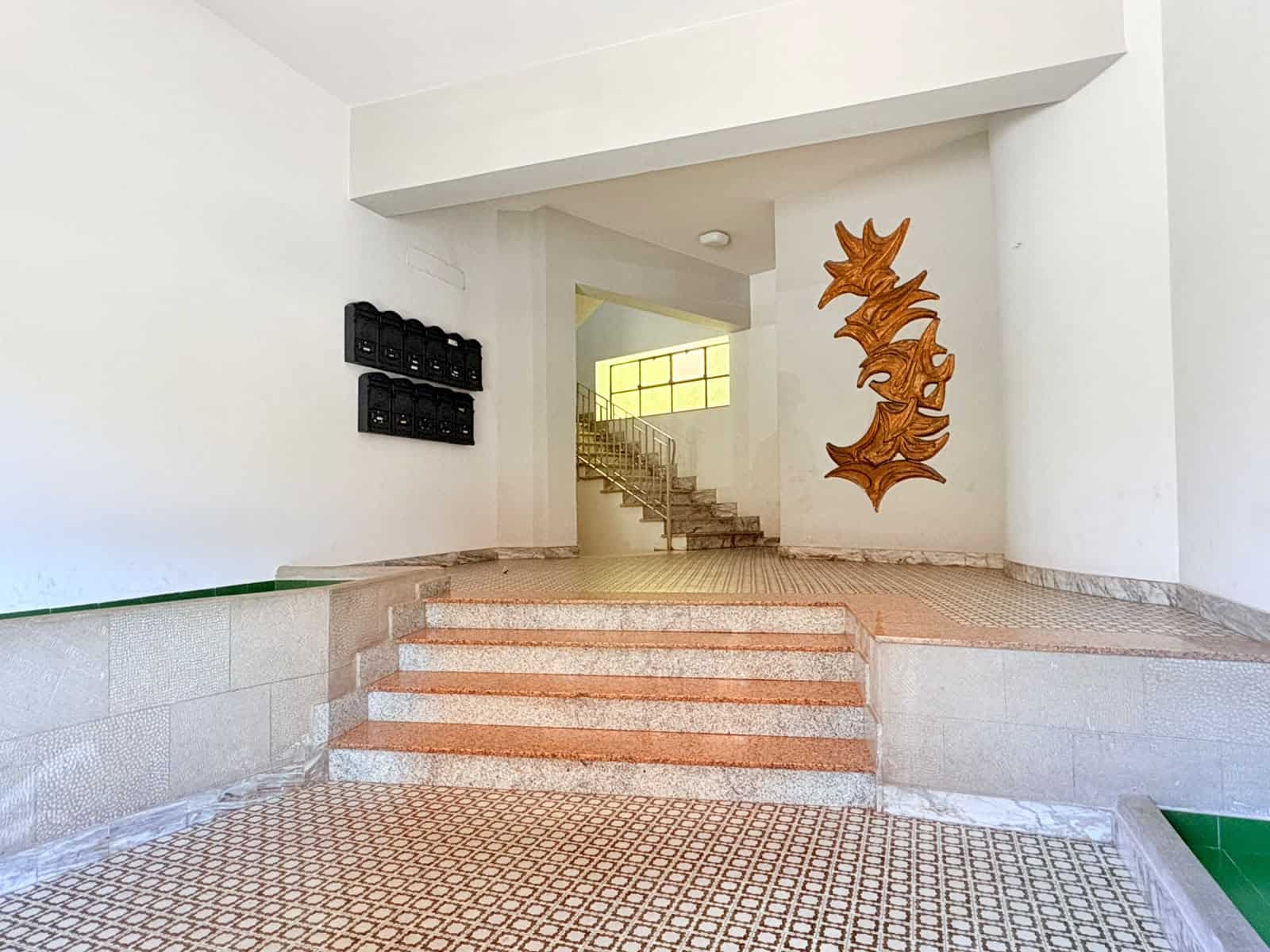 Ingresso condominiale con scale e decorazioni artistiche, zona di accesso all'edificio in Via Colonnello F. Magistri 27, Milazzo, ME.