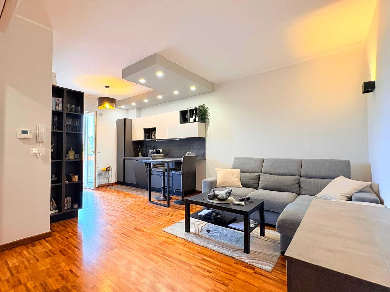 Interno di un appartamento in vendita a Milazzo, soggiorno con divano e cucina moderna.