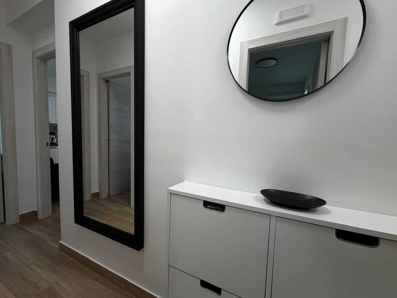 Specchio grande e mobile con lavabo in un ingresso di appartamento a Milazzo, ME.