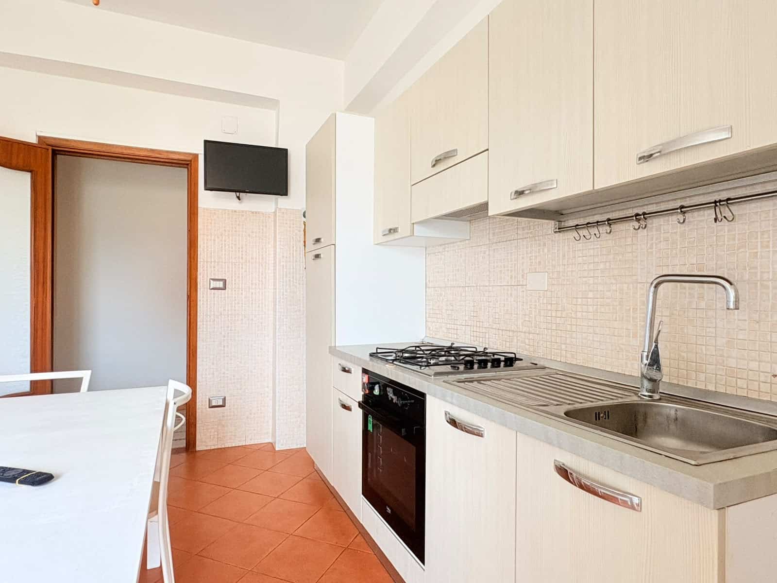 Cucina moderna in appartamento in affitto a Milazzo con elettrodomestici e mobili bianchi.