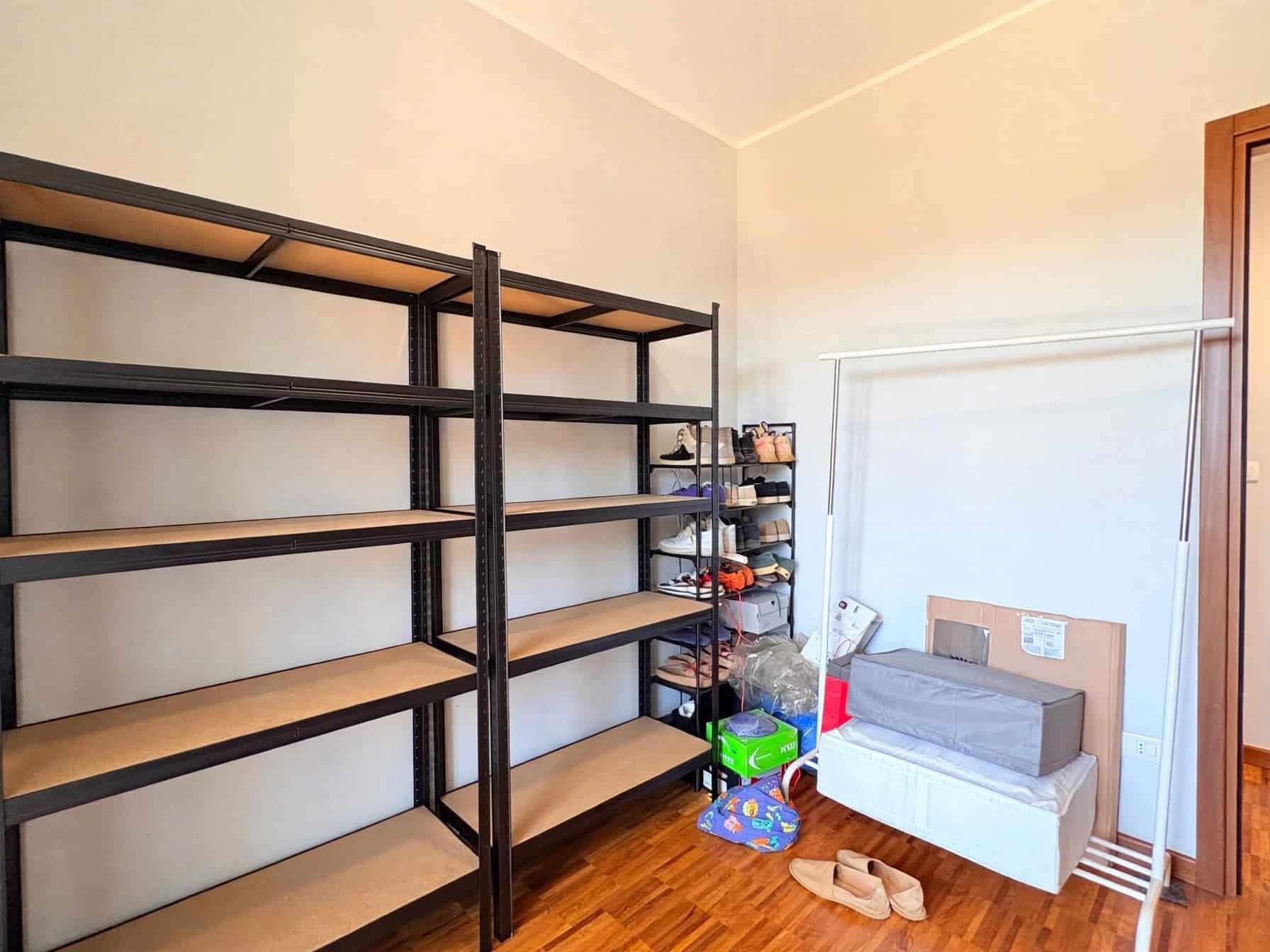 Interno di un appartamento in vendita a Milazzo con scaffali e armadio.