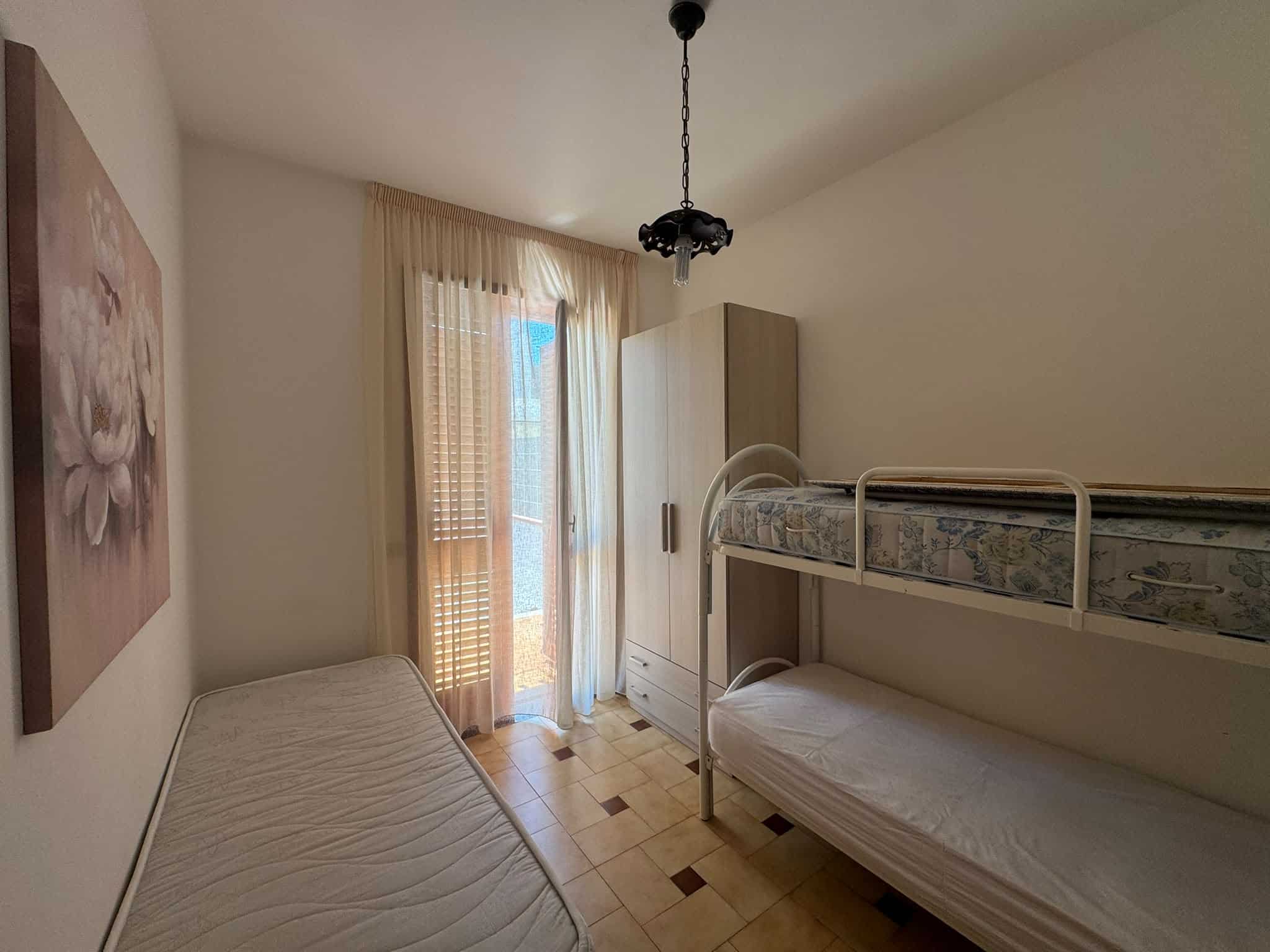 Camera da letto con letti a castello e armadio, luce naturale, in un appartamento in vendita a Milazzo.