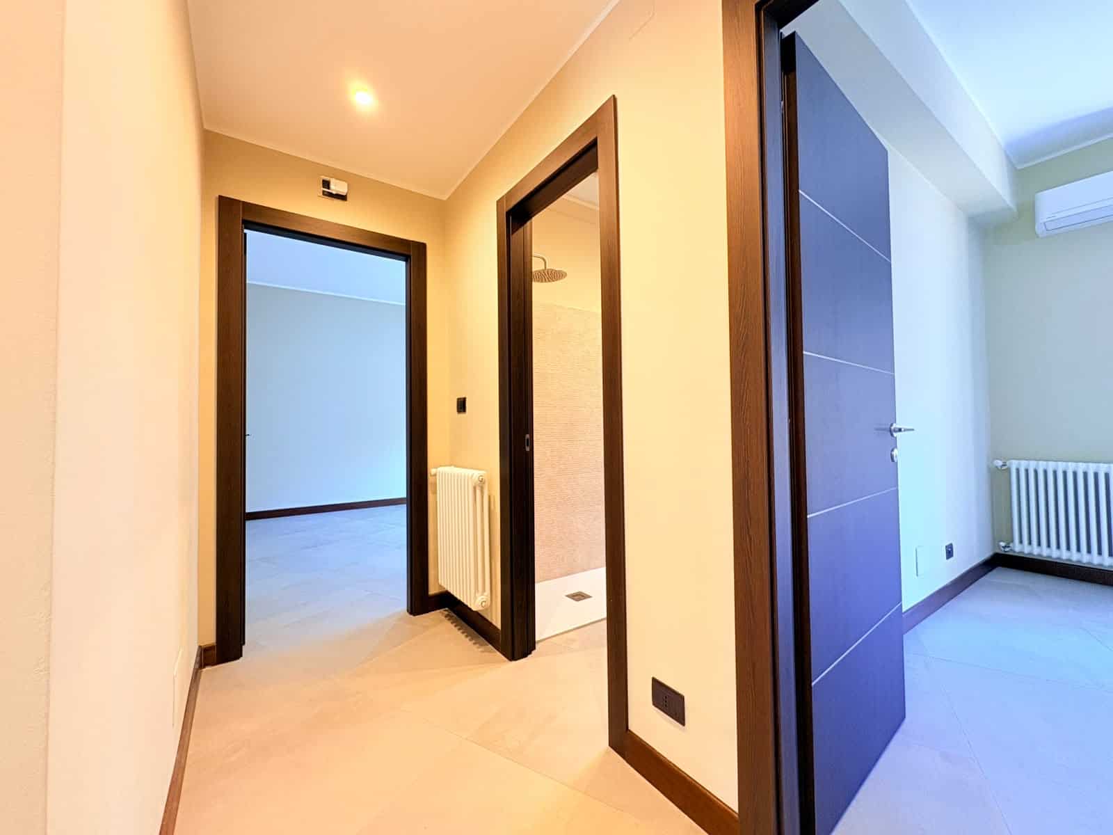 Interno di un appartamento in vendita a Milazzo, vista corridoio con porte e radiatore.