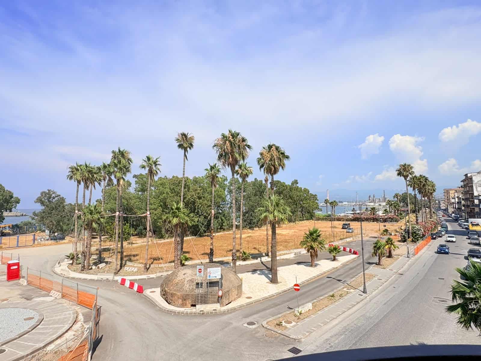 Vista panoramica di un'area con palme, strada e mare sullo sfondo a Milazzo, ME.