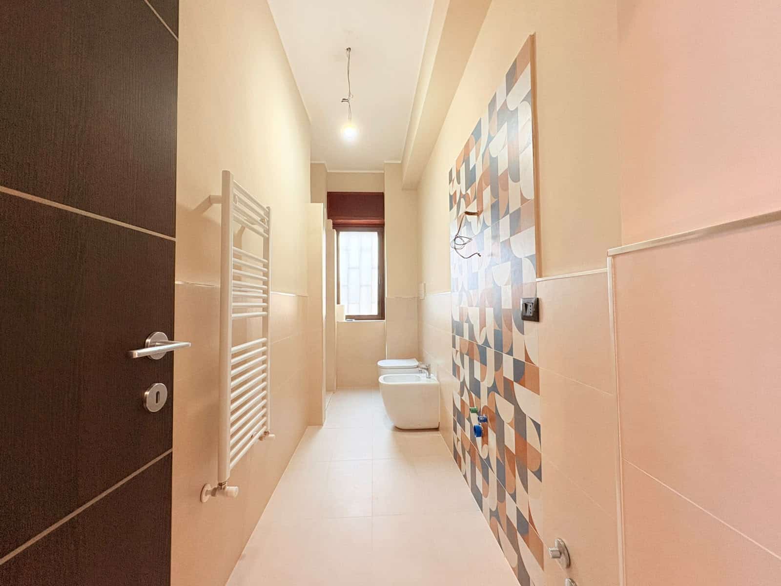 Bagno spazioso con pareti colorate e finestra, ideale per appartamento in vendita a Milazzo.