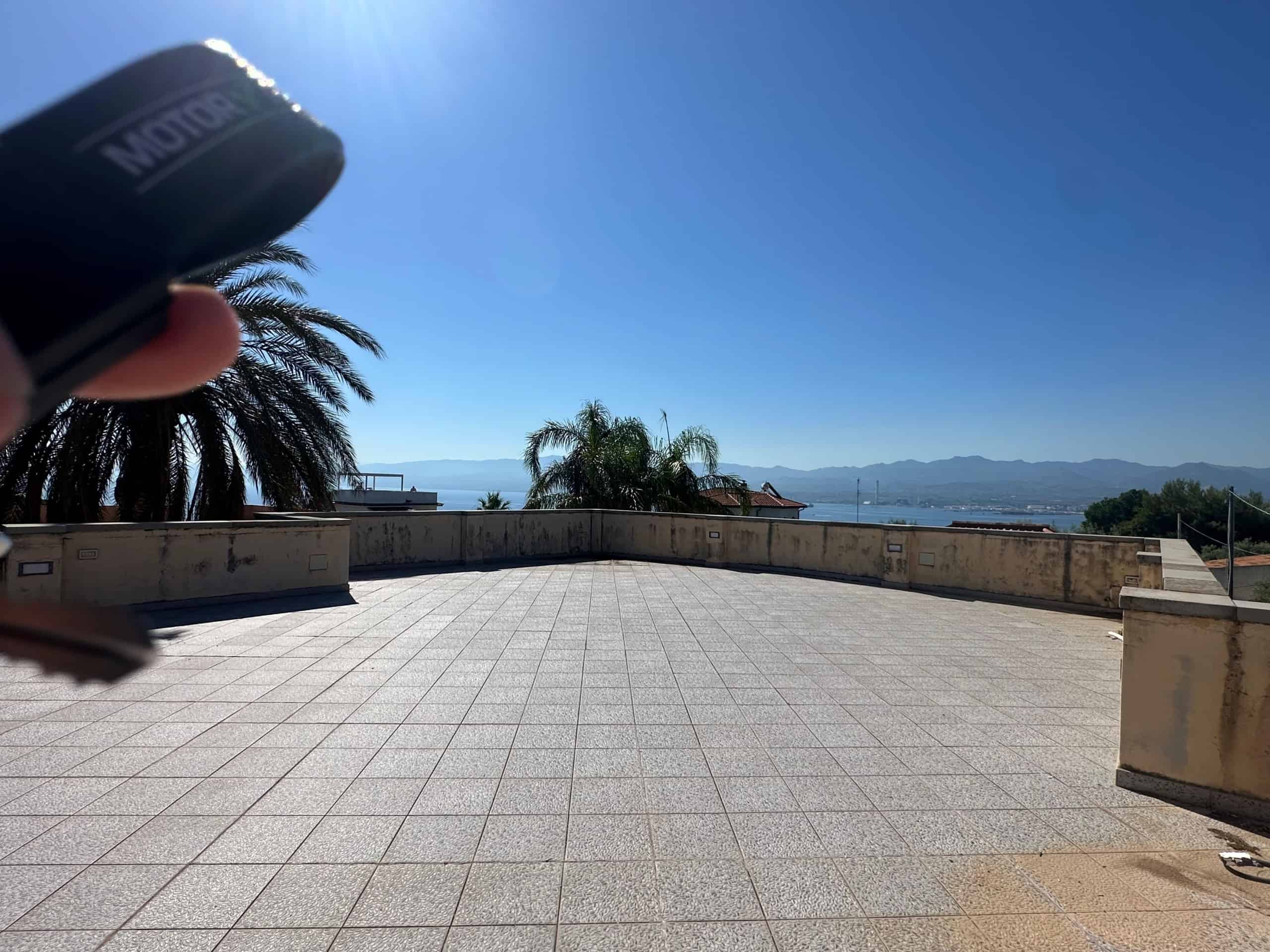 Terrazza panoramica con vista mare e palme, ideale per relax e convivialità.