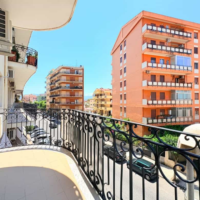 Balcone di un appartamento in vendita a Milazzo con vista su edifici moderni e il cielo azzurro.