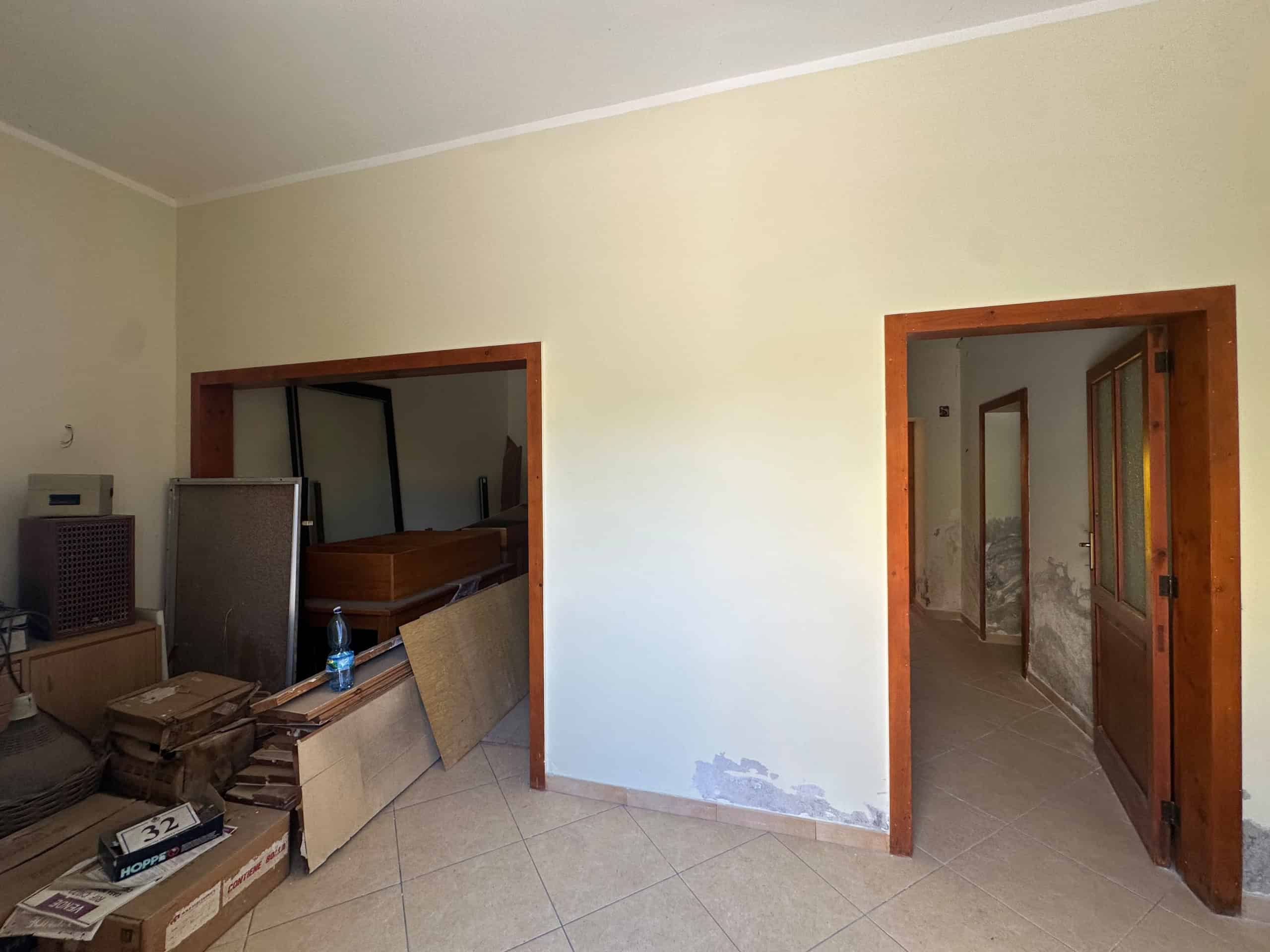 Interno di una casa indipendente in vendita a Milazzo, con pareti da ristrutturare e mobili vecchi.