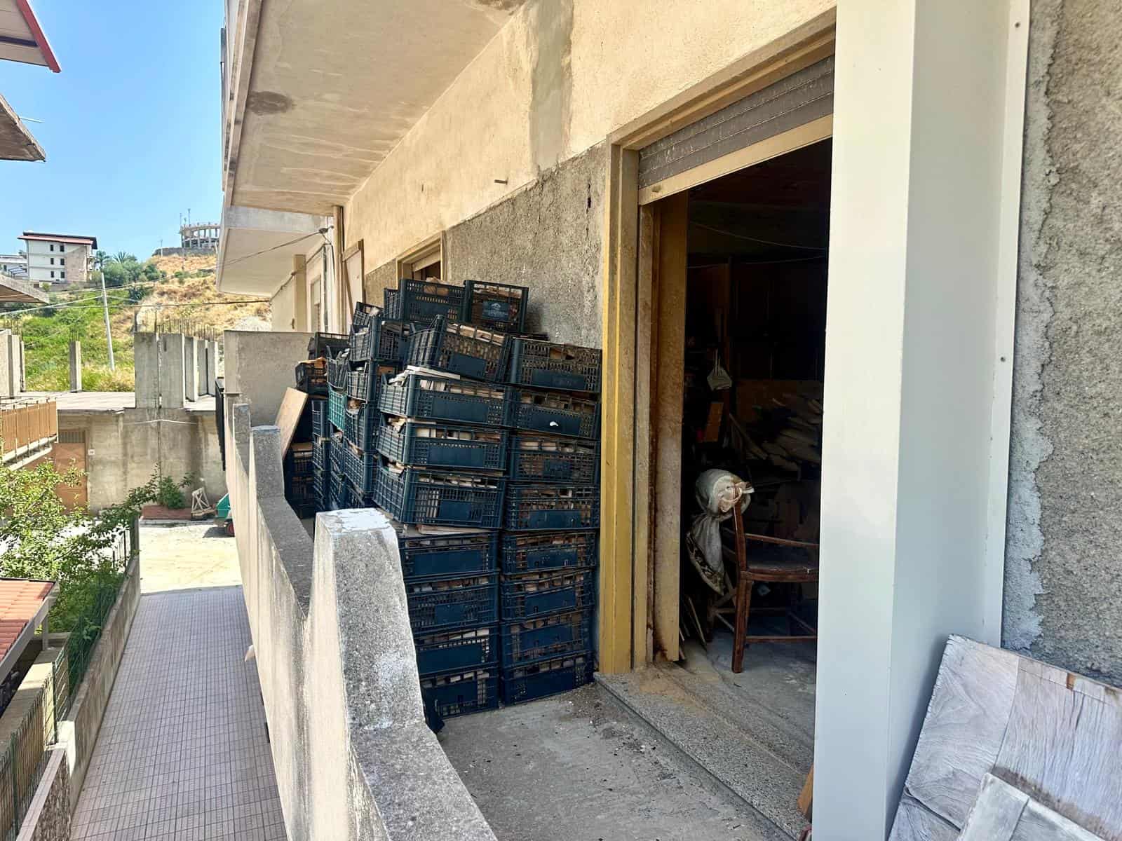 Casse di plastica nere impilate all'esterno di un edificio in costruzione o ristrutturazione.