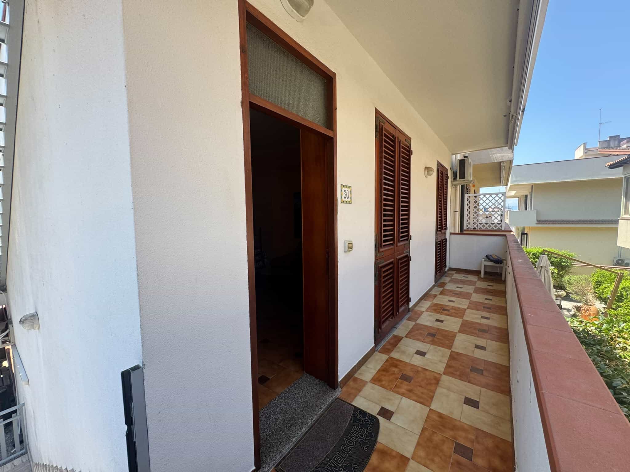 Balcone spazioso di una villa in vendita in via Delle Magnolie 30, Milazzo, con vista sulla città e sul mare.