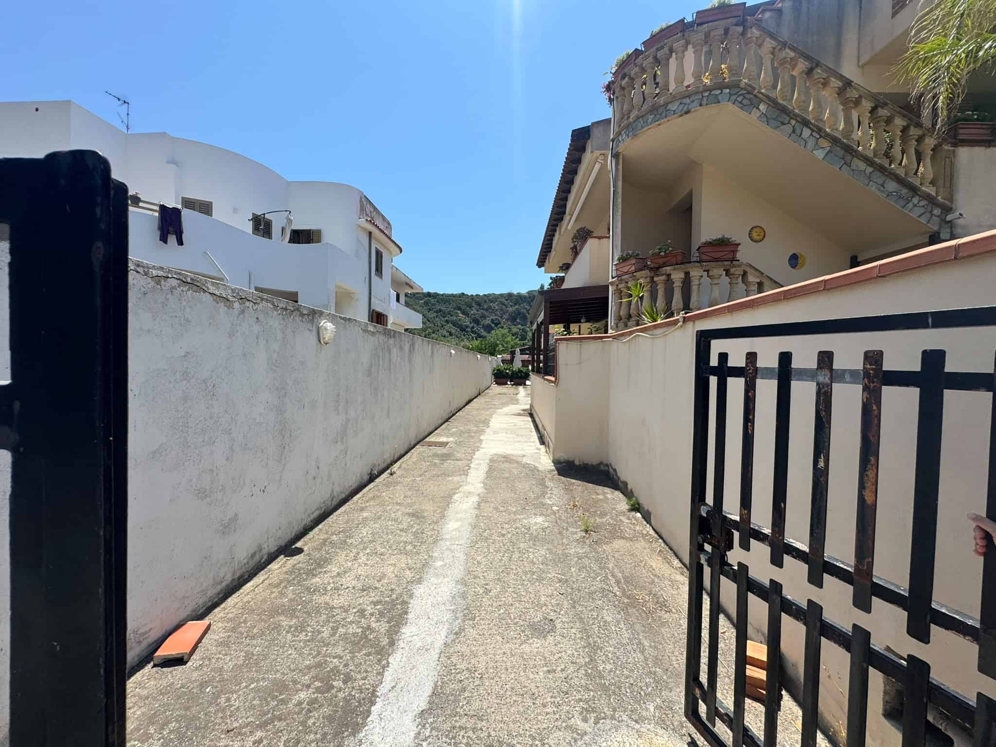 Vicolo in via Delle Magnolie a Milazzo con case residenziali e cielo sereno, ideale per immobili in vendita nella zona.