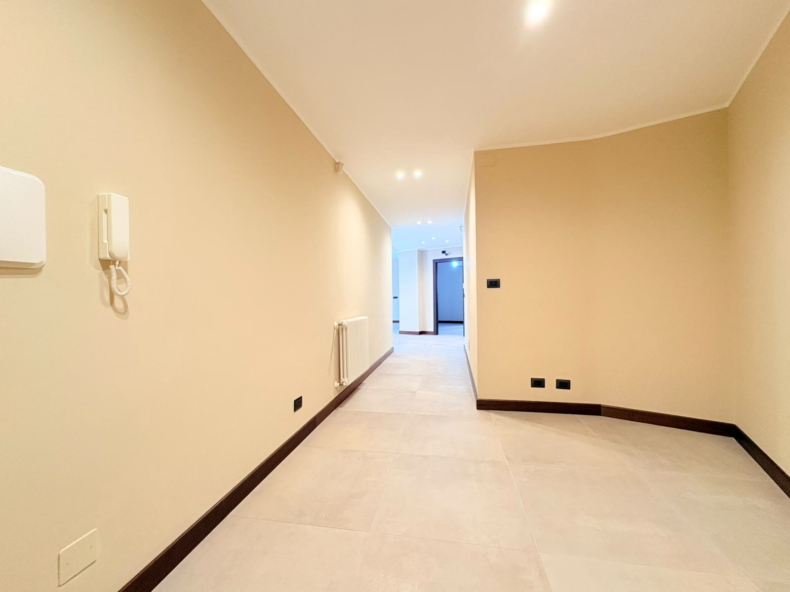 Interno di un appartamento moderno in vendita a Milazzo, con pareti beige, pavimento chiaro e illuminazione a soffitto.