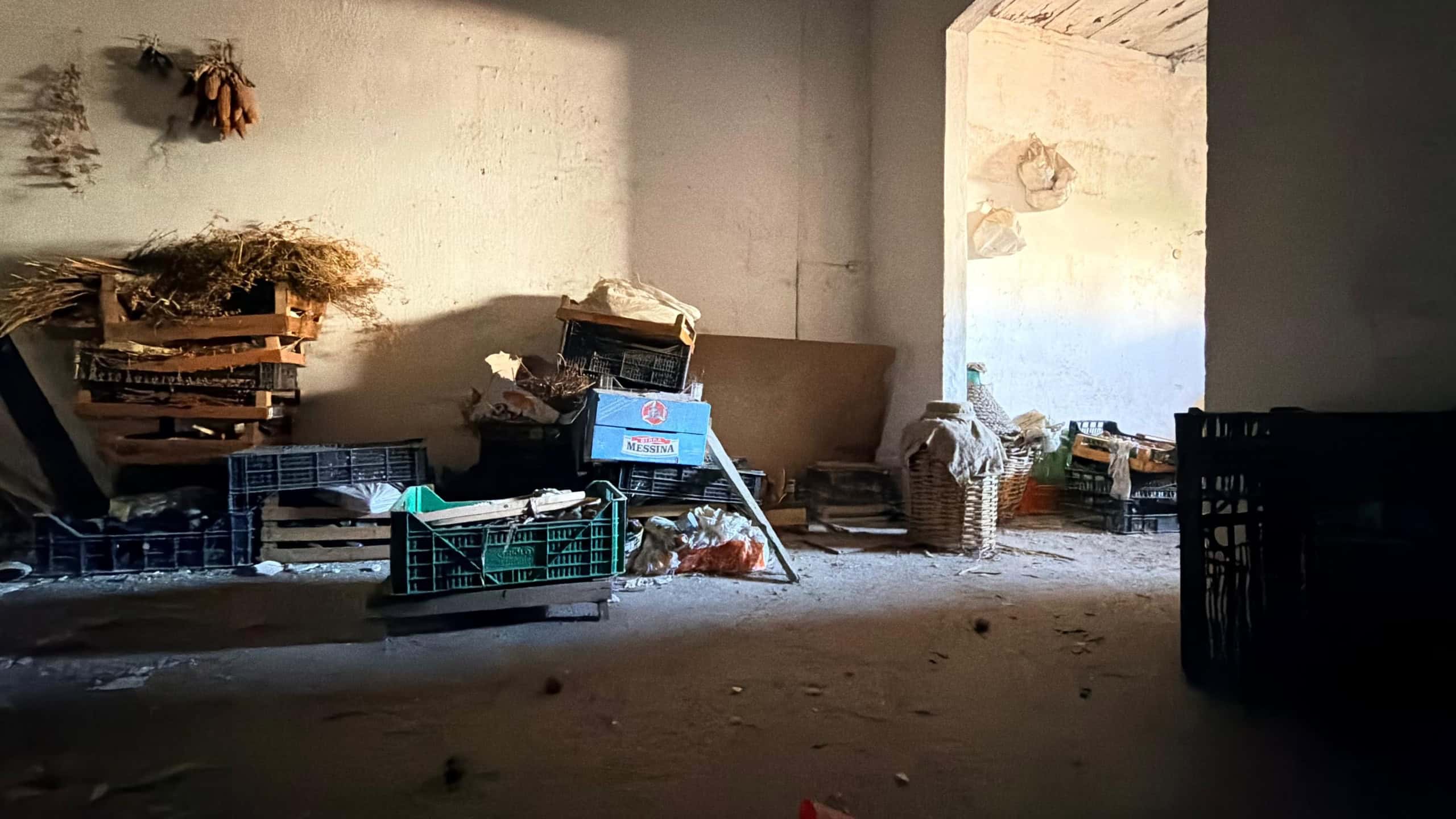 Interno di un edificio in fase di ristrutturazione con materiali di costruzione e attrezzi disposti in modo disordinato.