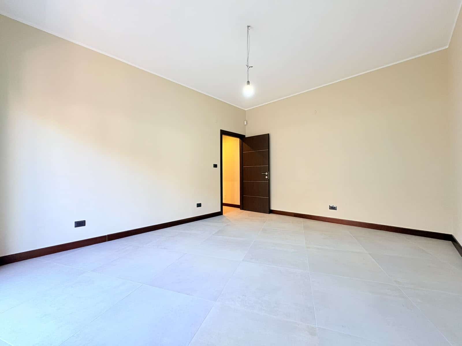 Stanza vuota in appartamento in vendita a Milazzo, con pareti beige e pavimento chiaro.