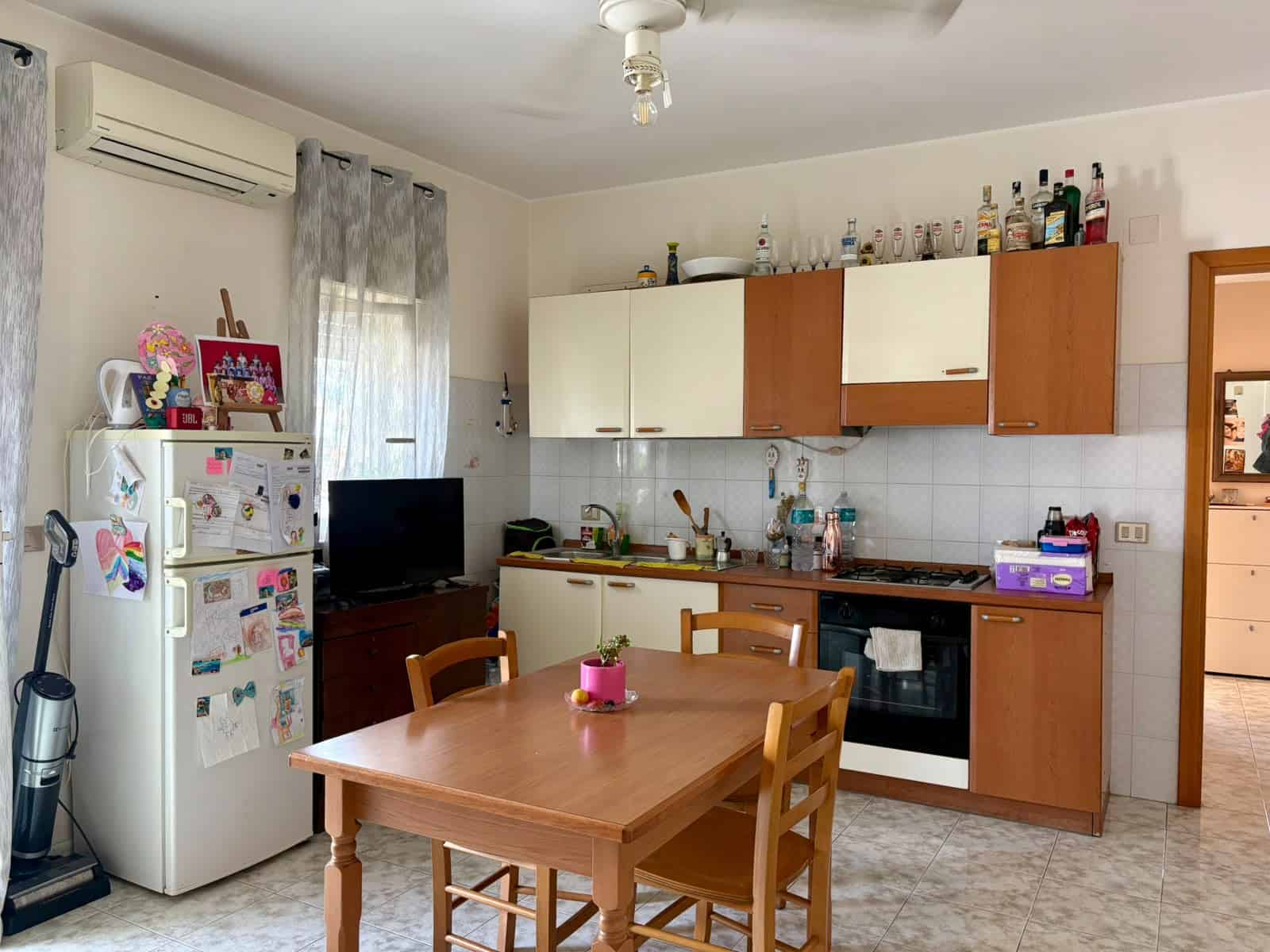 Cucina in appartamento con terrazzo in vendita a Tonnarella, Furnari, con mobili in legno e elettrodomestici.