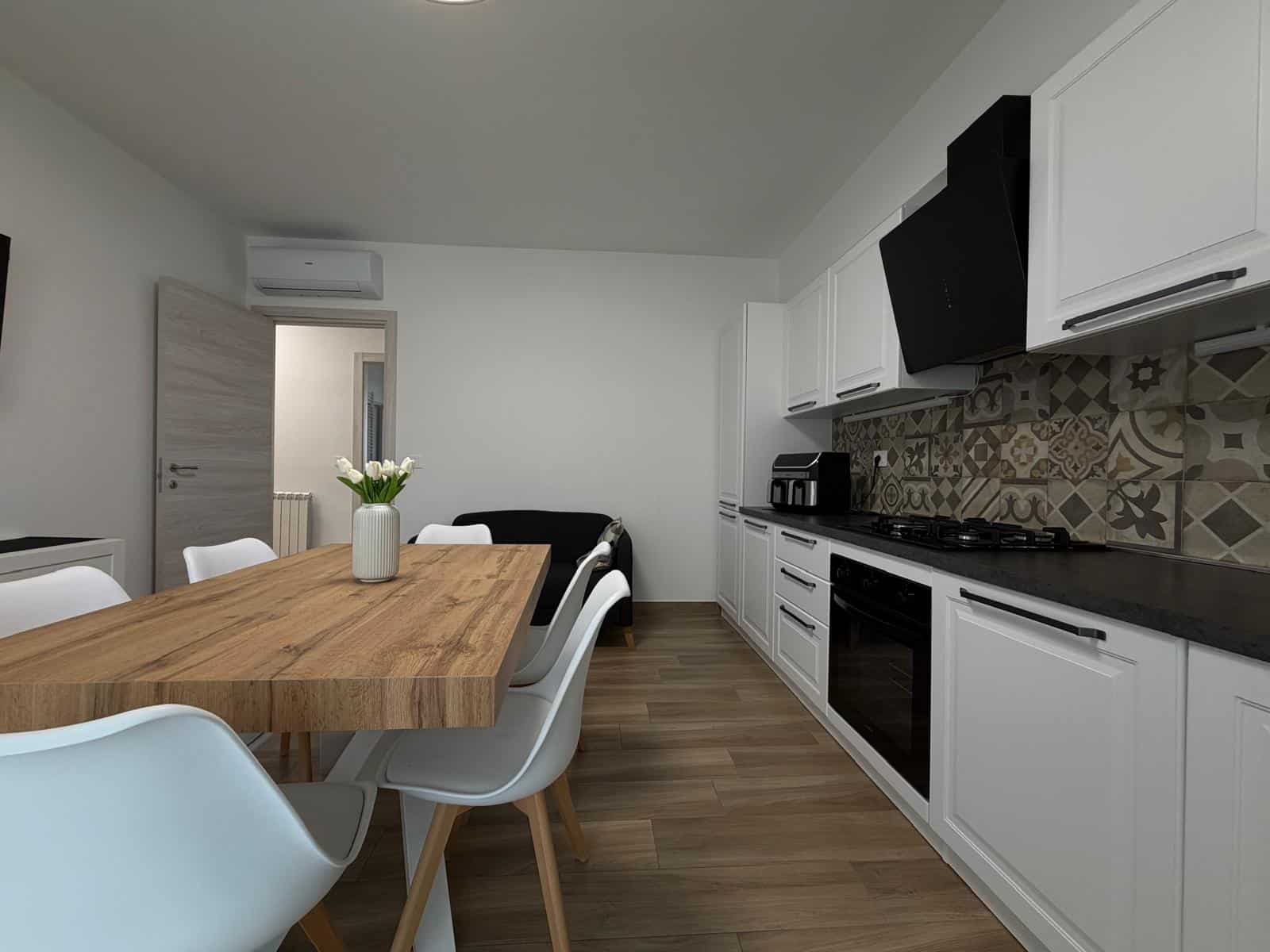 Interno di un appartamento in vendita a Milazzo con cucina moderna e zona pranzo.