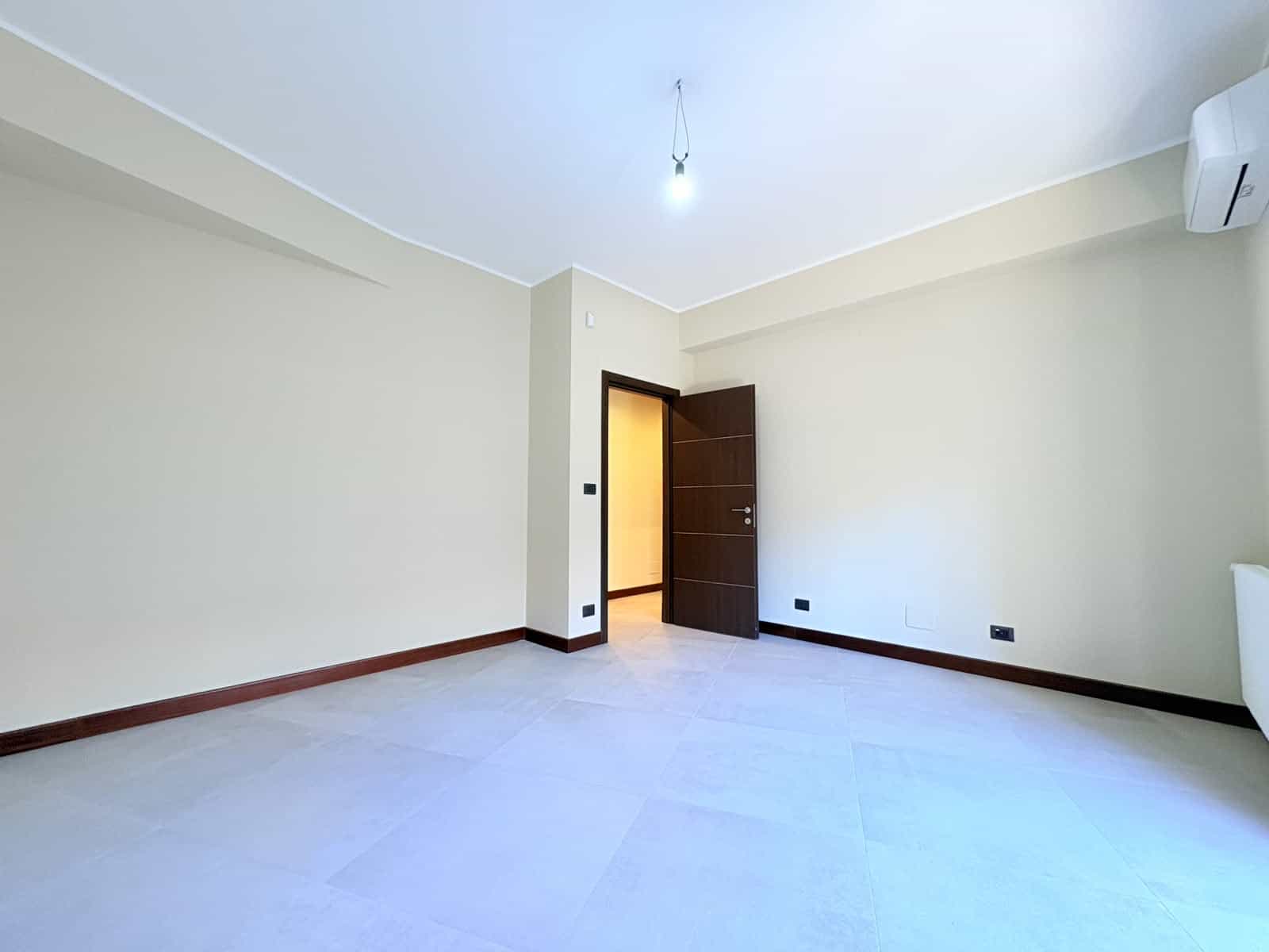 Stanza vuota in appartamento in vendita a Milazzo, con pareti beige e pavimento chiaro.