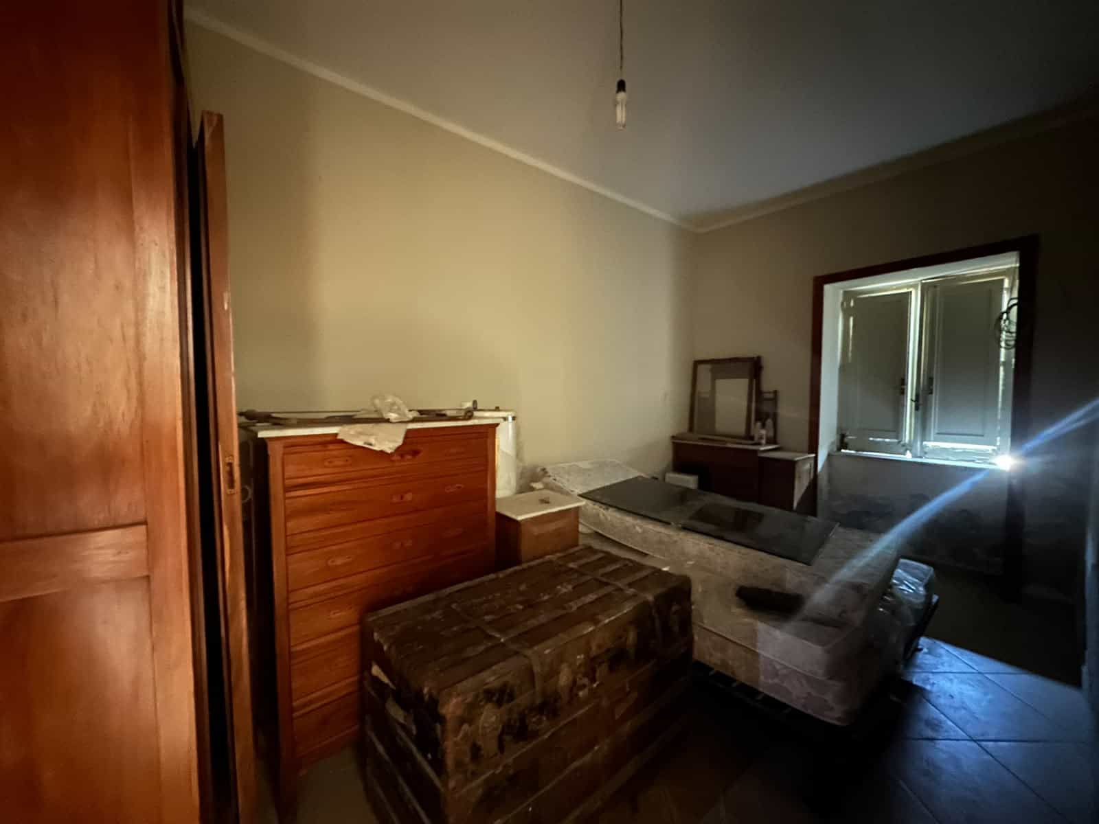 Interno di una casa indipendente in vendita a Milazzo, con mobili vecchi e pareti neutre.