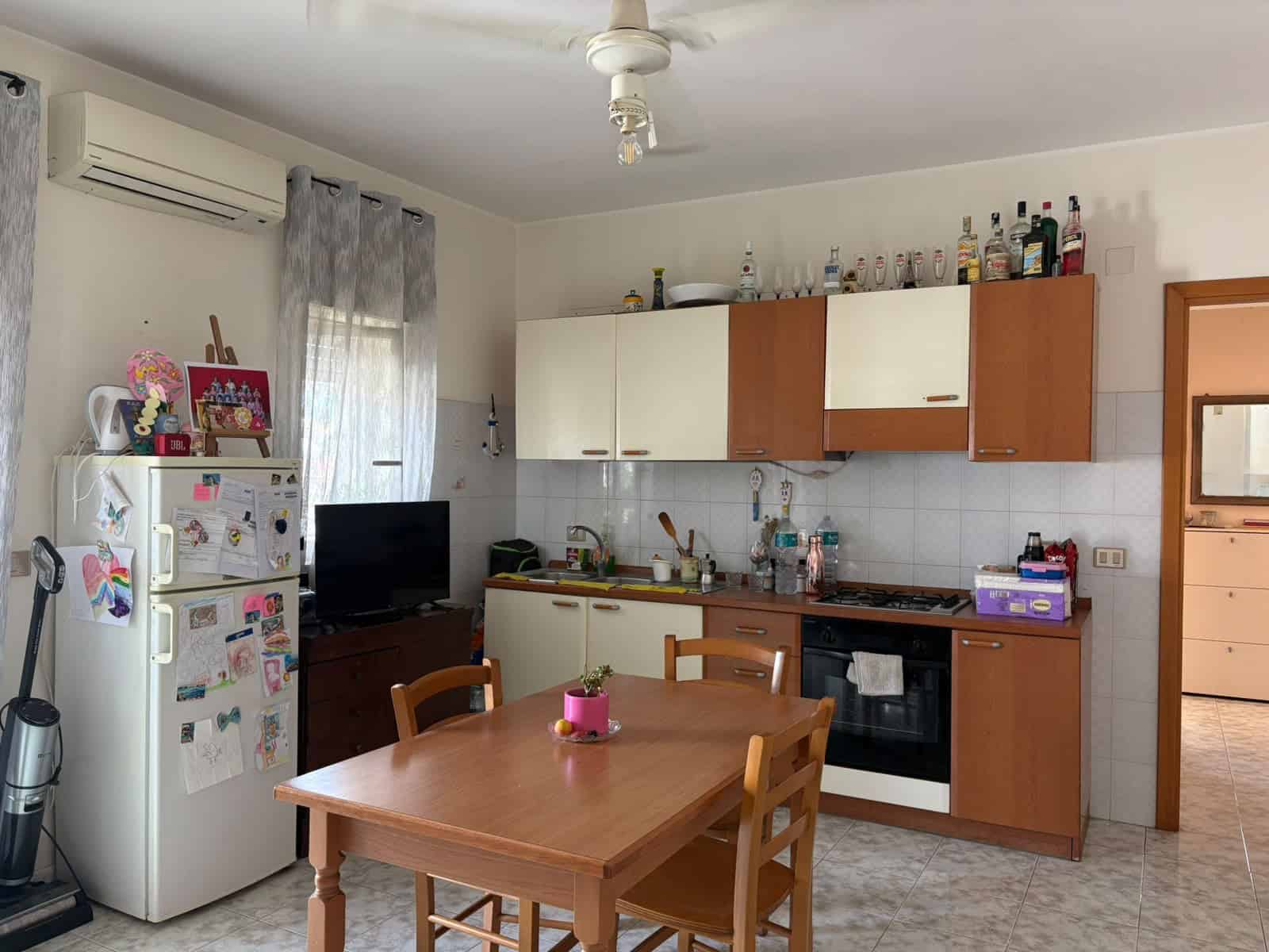 Interno di un appartamento con cucina e zona pranzo, arredato in stile semplice e funzionale.