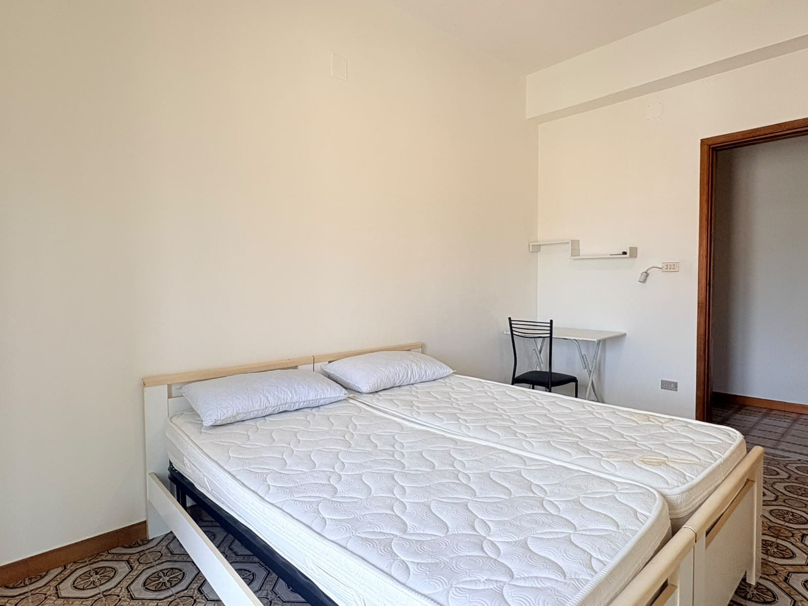 Camera da letto con letto matrimoniale e arredi semplici in un appartamento in affitto a Milazzo.