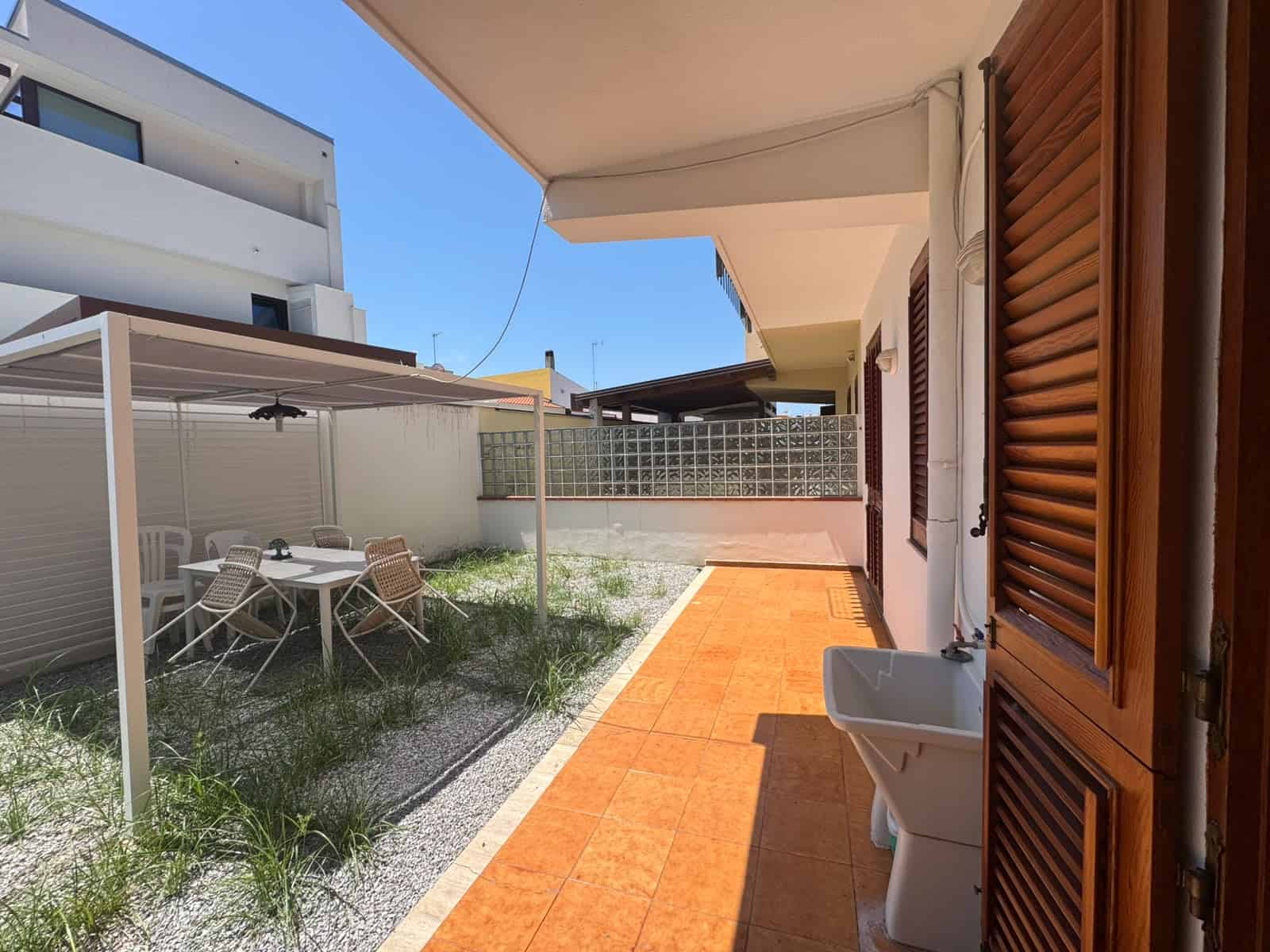 Veranda di una villa in vendita a Milazzo con area esterna e spazio per tavolo e sedie.