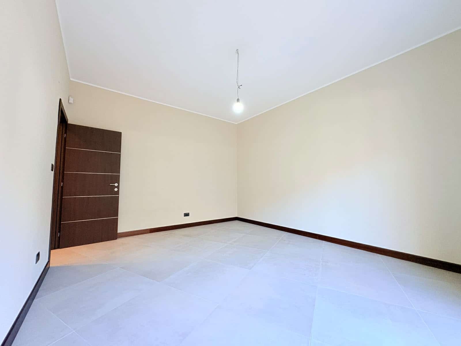 Stanza vuota in appartamento in vendita a Milazzo, con pareti beige e pavimento chiaro.